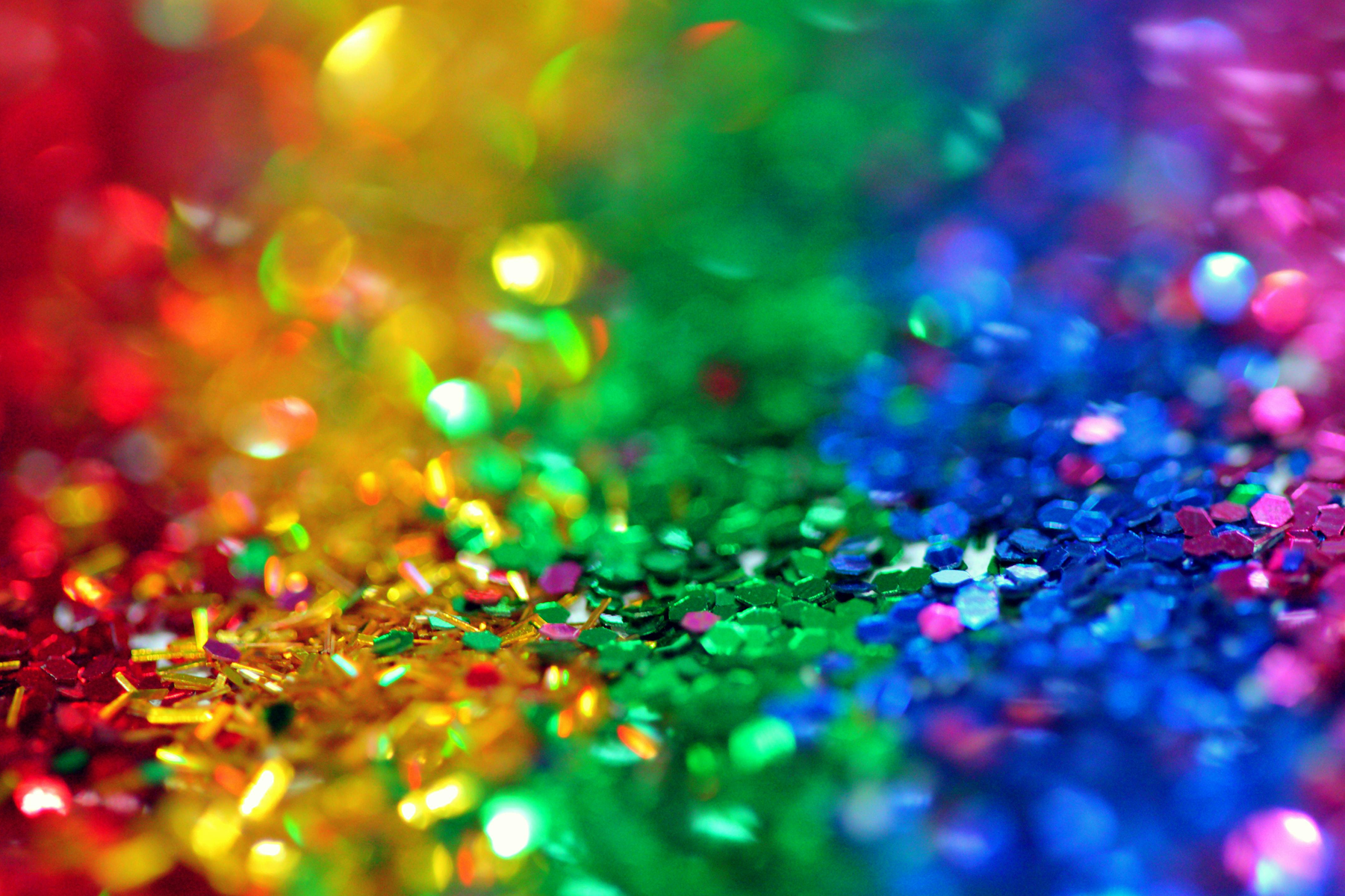 A close-up photo of rainbow colored glitter.