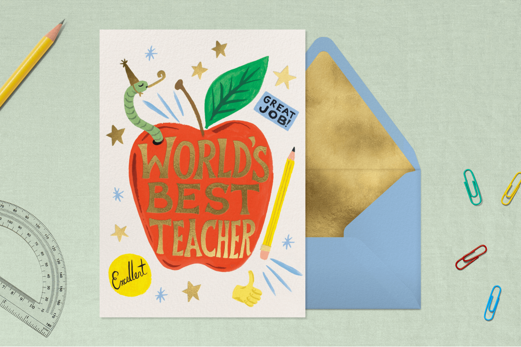 A card with a worm in a party hat and a red apple with the words WORLD’S BEST TEACHER surrounded by school supplies.