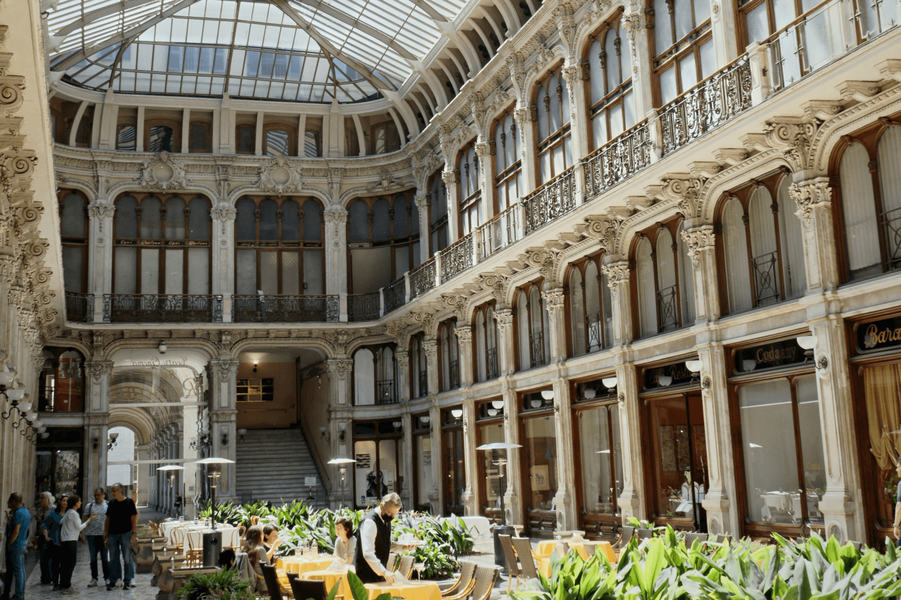 An interior courtyard of a historic building with tables and chairs for dining.