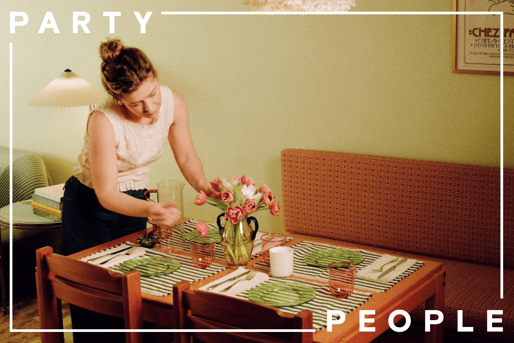 Katherine Lewin sets a dining table with striped placemats, green plates, and a vase with pink and white flowers. The words “PARTY PEOPLE” border the photo.