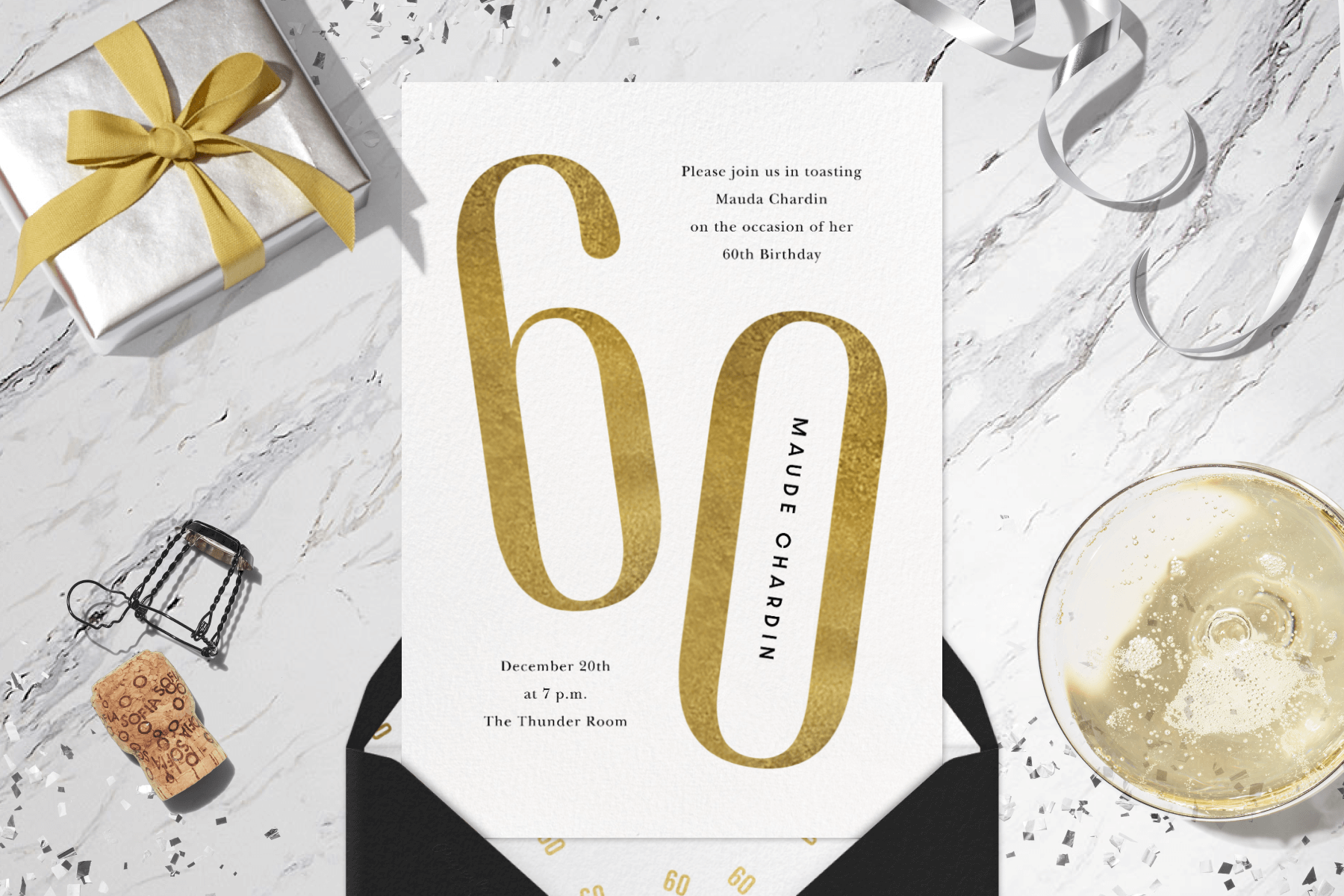 A 60th birthday invitation with a large gold 60, surrounded by a present, ribbon, a glass of Champagne, and a cork.