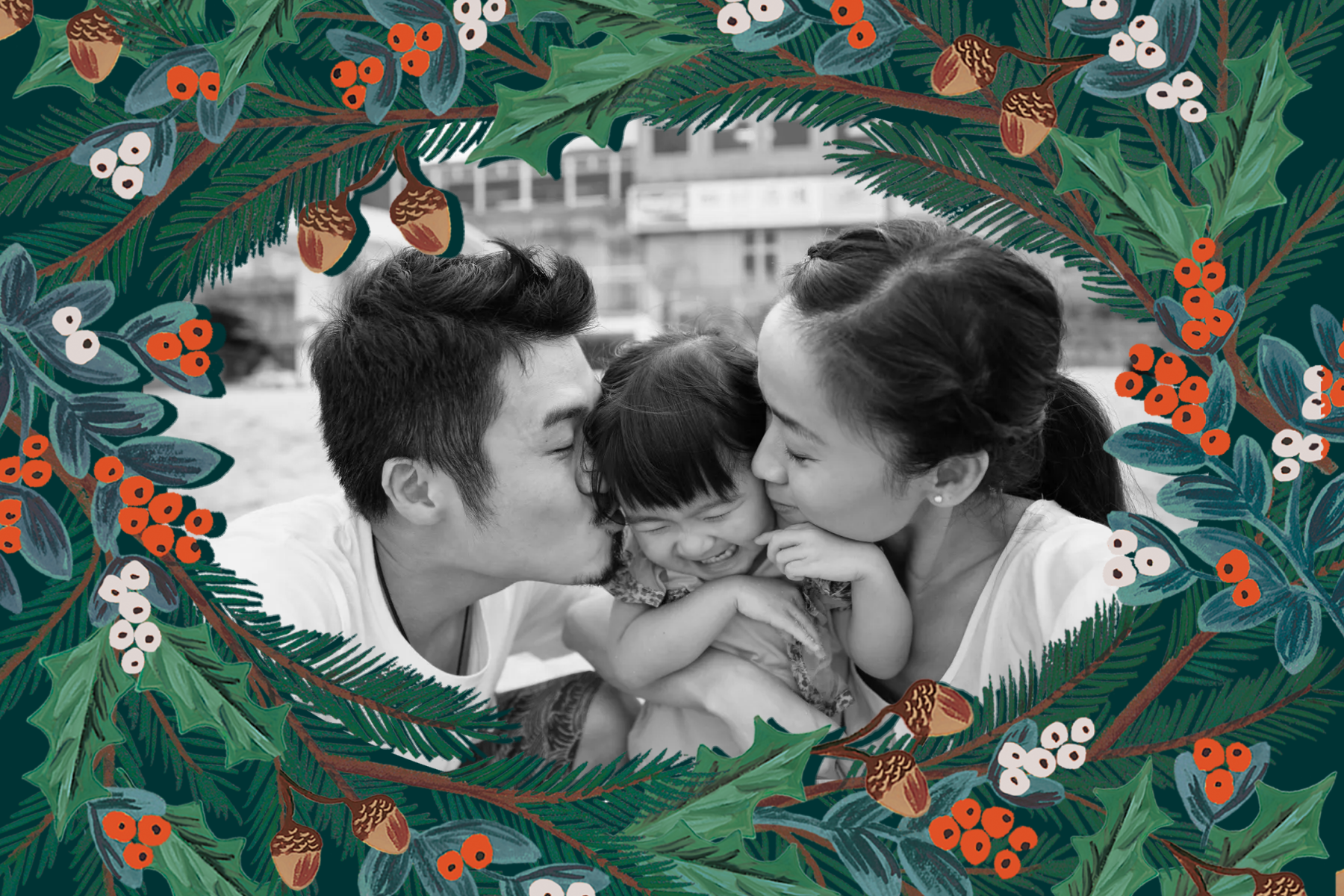 Two parents kissing their child on the cheek surrounded by a festive greenery frame.