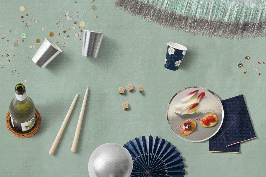 An animated gif of several flatlays of party supplies like balloons, plates, and candles.