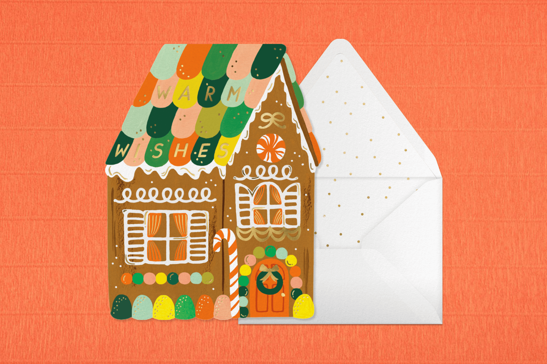 A card in the shape of a gingerbread house decorated with candy.