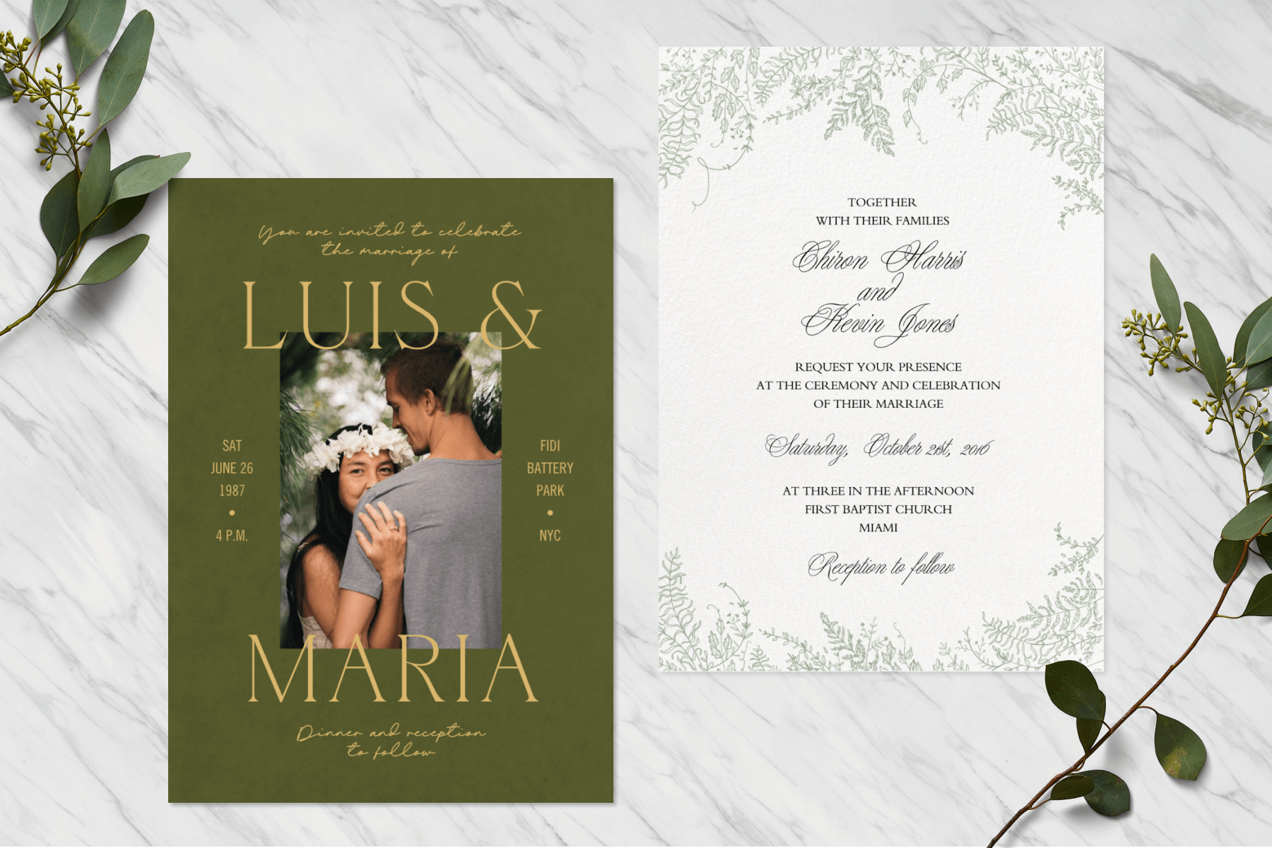 Two wedding invitations are side by side on a white marble surface with sprigs on either side.