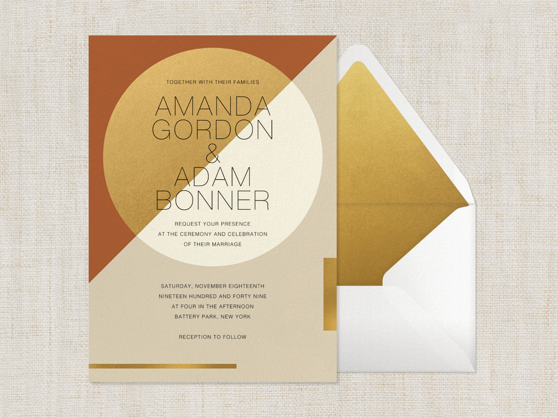 An earth tone, color blocked wedding invitation with a circle split into two colors and geometric gold accents beside a white envelope with gold liner on a cloth background.