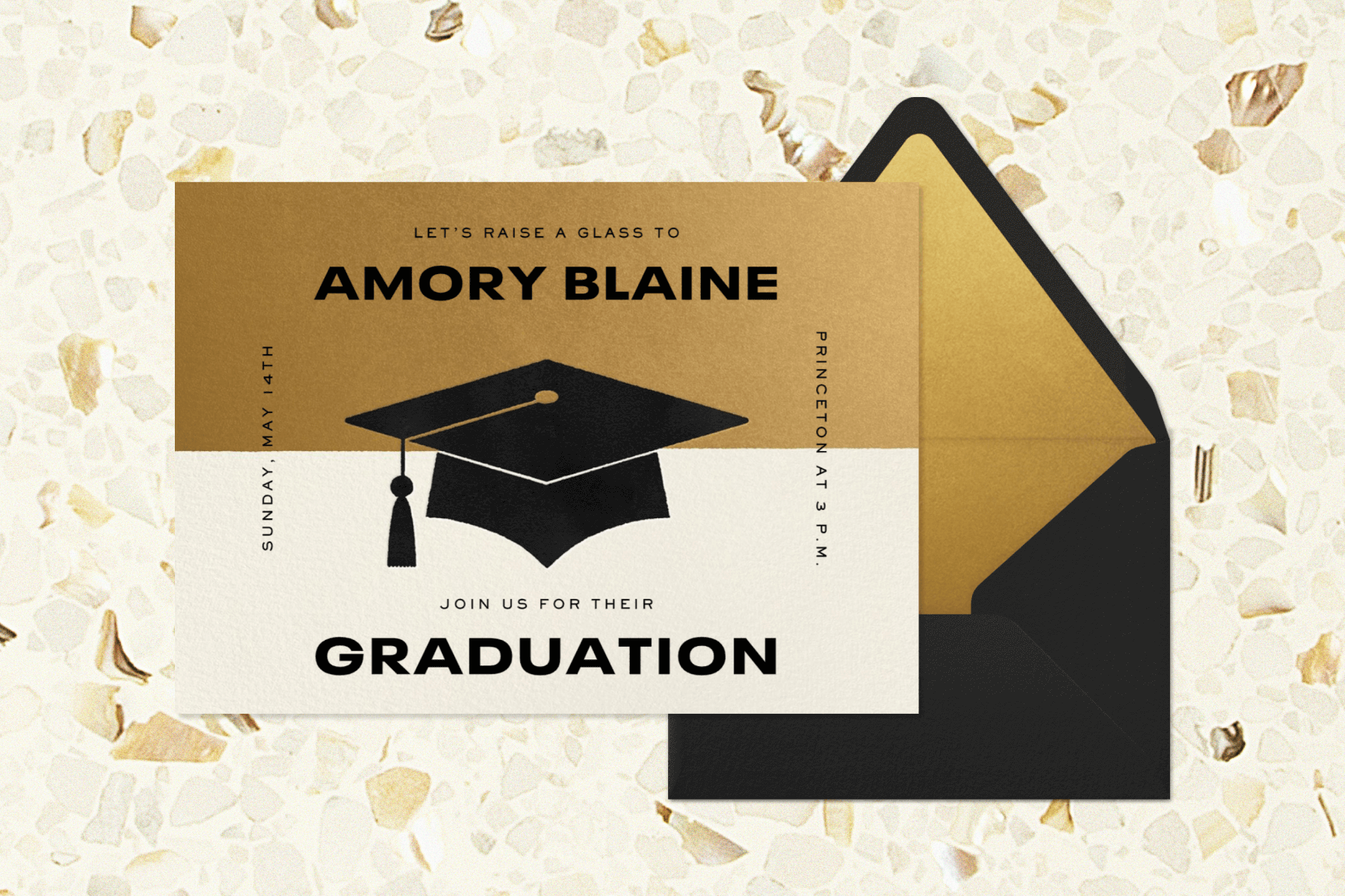 A gold and cream-split graduation invitation with a mortarboard in the center beside a black envelope with gold liner