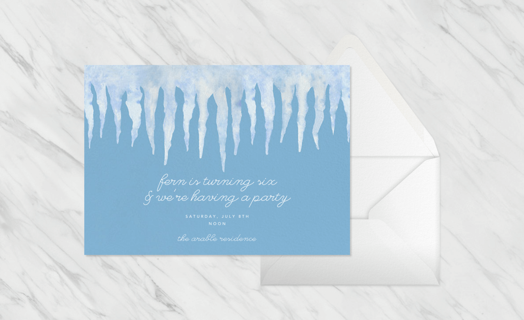 A blue birthday invitation with illustrations of icicles, paired with an envelope.