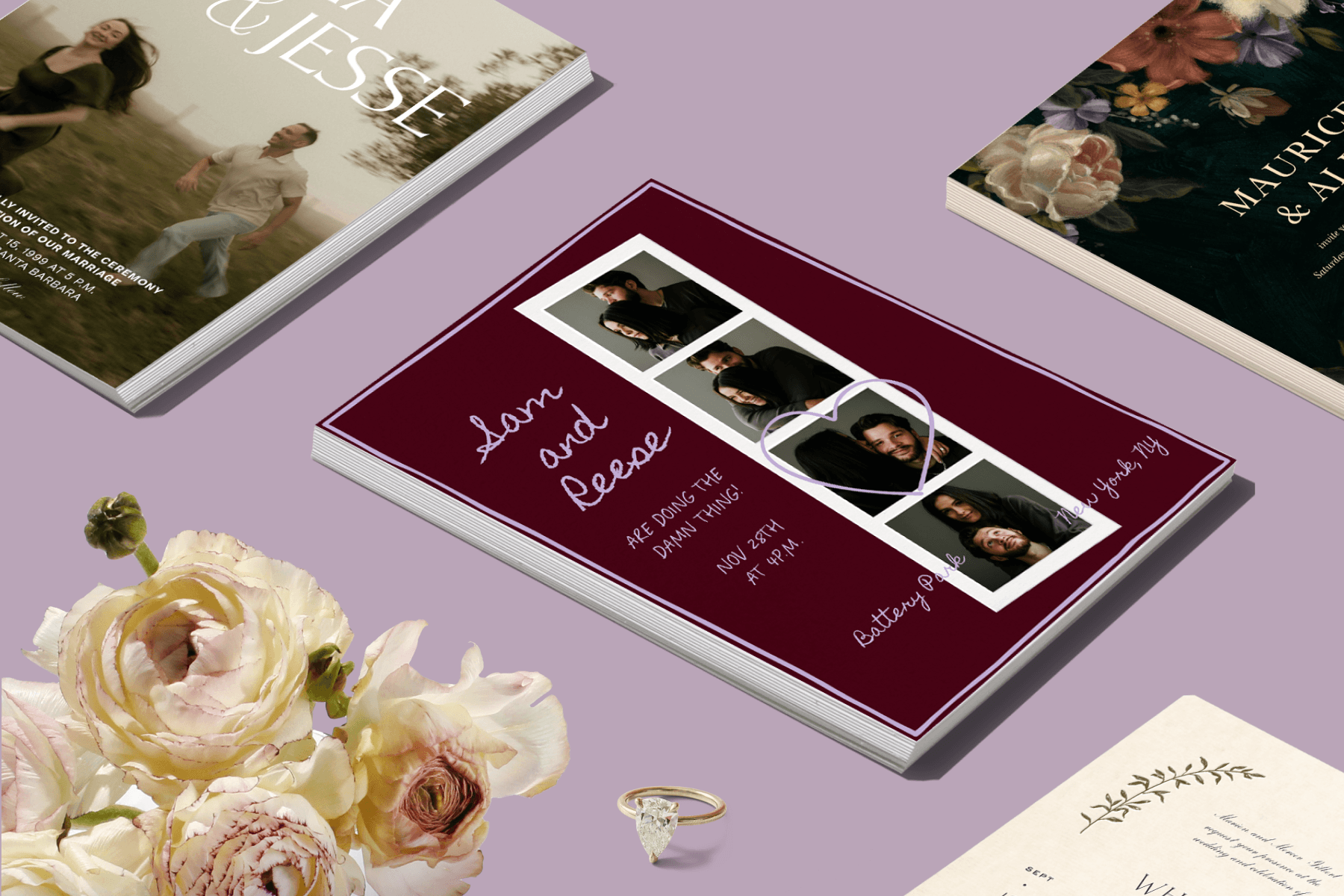 On a purple backdrop are several stacks of various wedding save-the-date cards, an engagement ring, and white flowers.