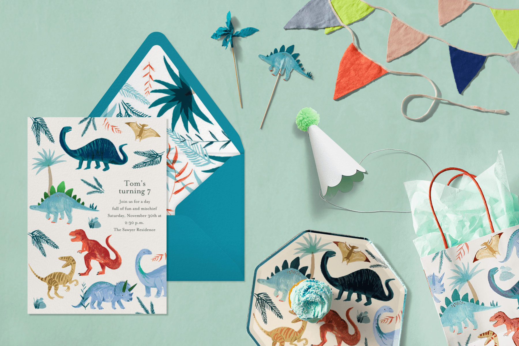 Dinosaur-themed invitation and party supplies.