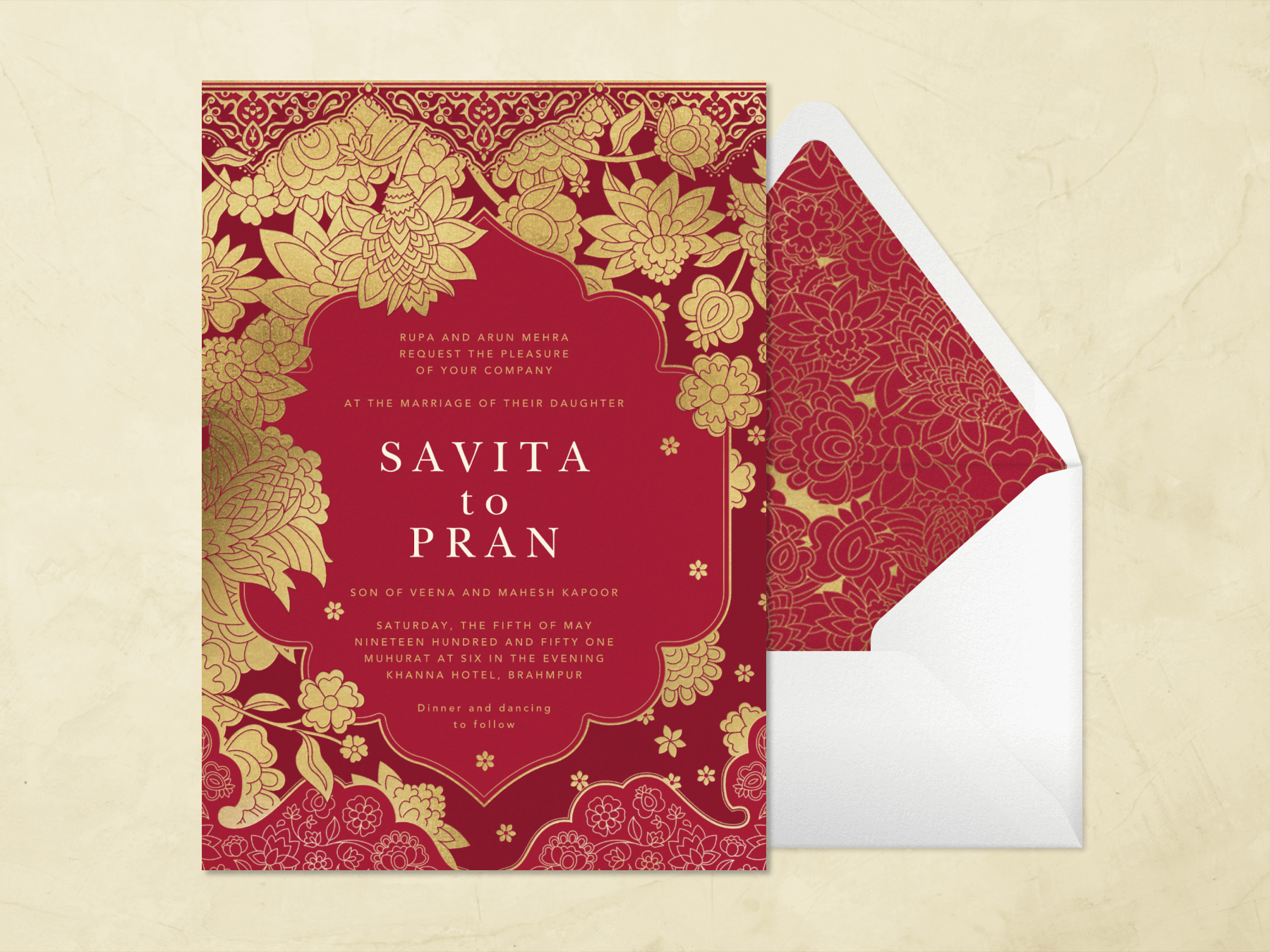 A maroon wedding invitation with Indian-style gold floral illustrations forming a border beside a white envelope with a liner that matches the invitation.