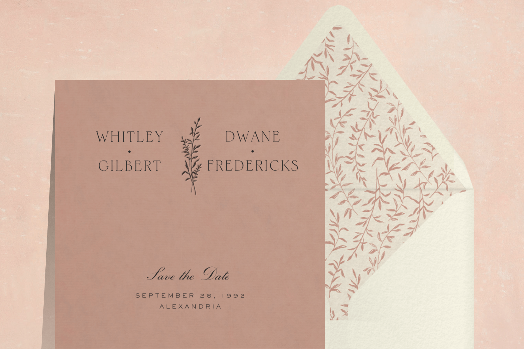 A dusty pink save the date with a silhouetted sprig between the couple’s names and a white envelope with matching pink sprigs on the liner.