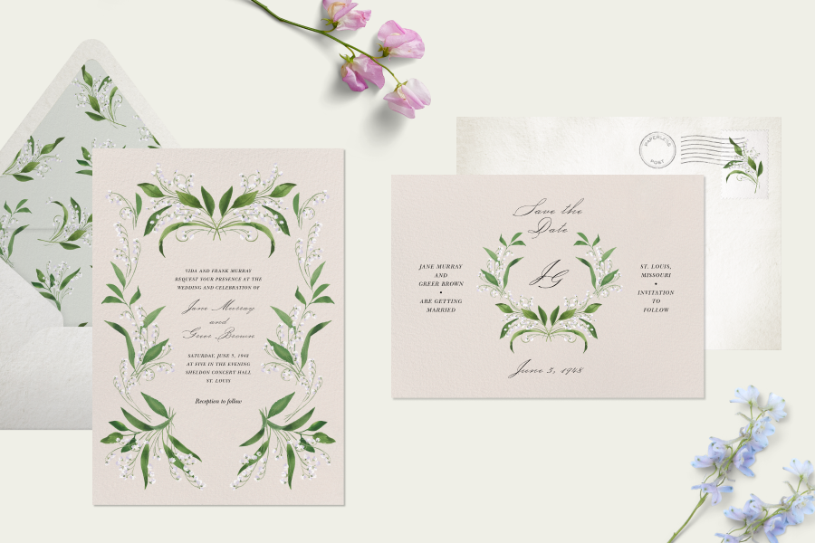 A wedding invitation and save the date on off-white cards feature Lily of the Valley floral designs. The scene is propped with flowers and features a light green background. 