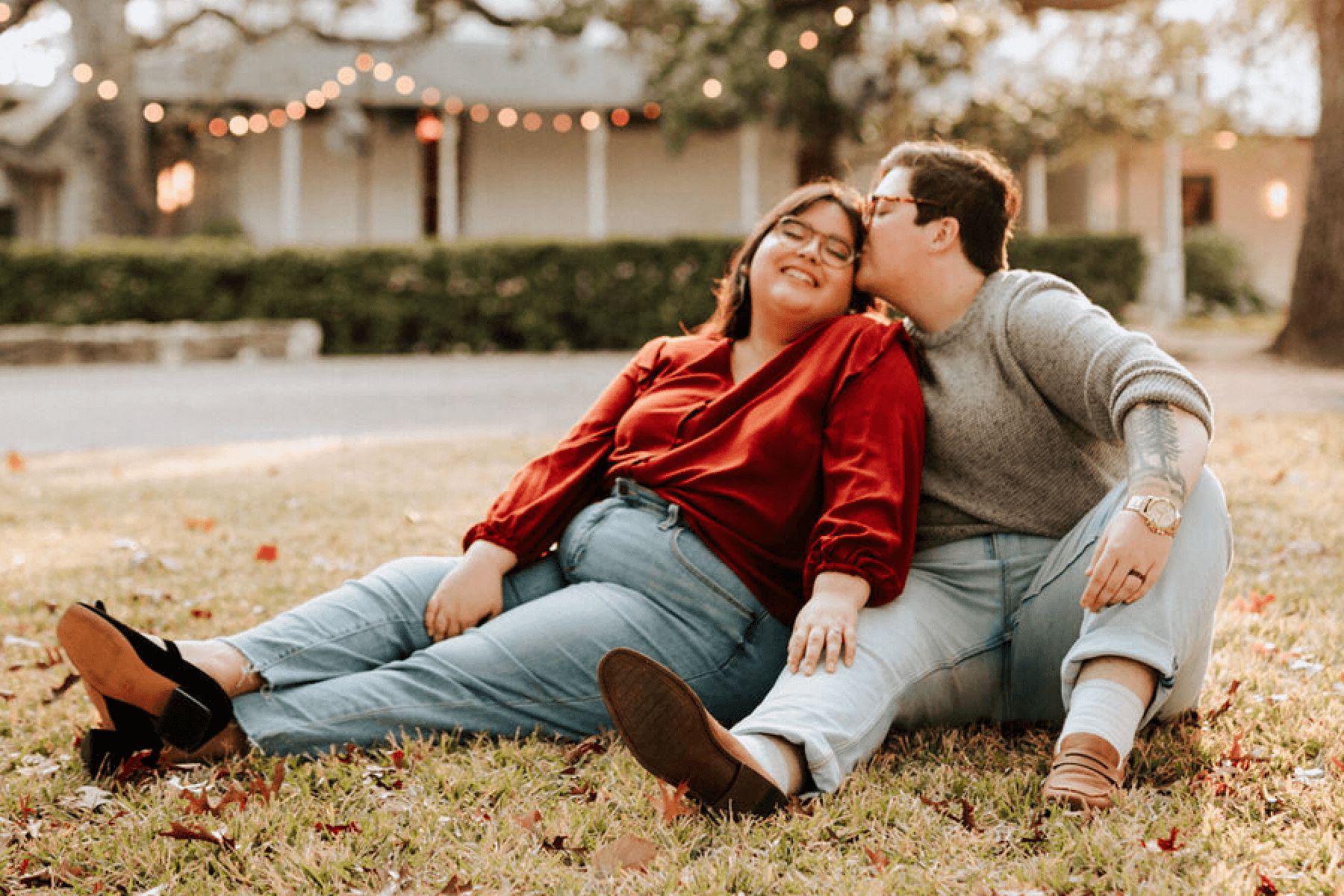 Two women sitting outside posing for engagement photos.