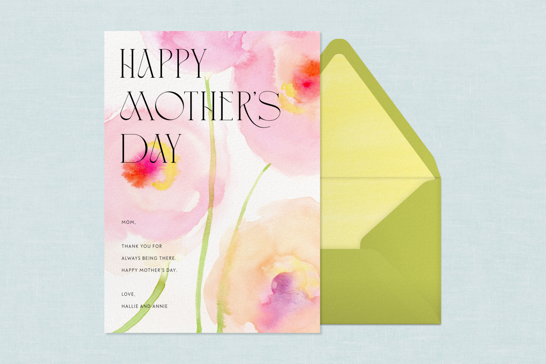 A Mother’s Day card with pink watercolor flowers and text reading ‘HAPPY MOTHER’S DAY’ over a blue background next to a green envelope.