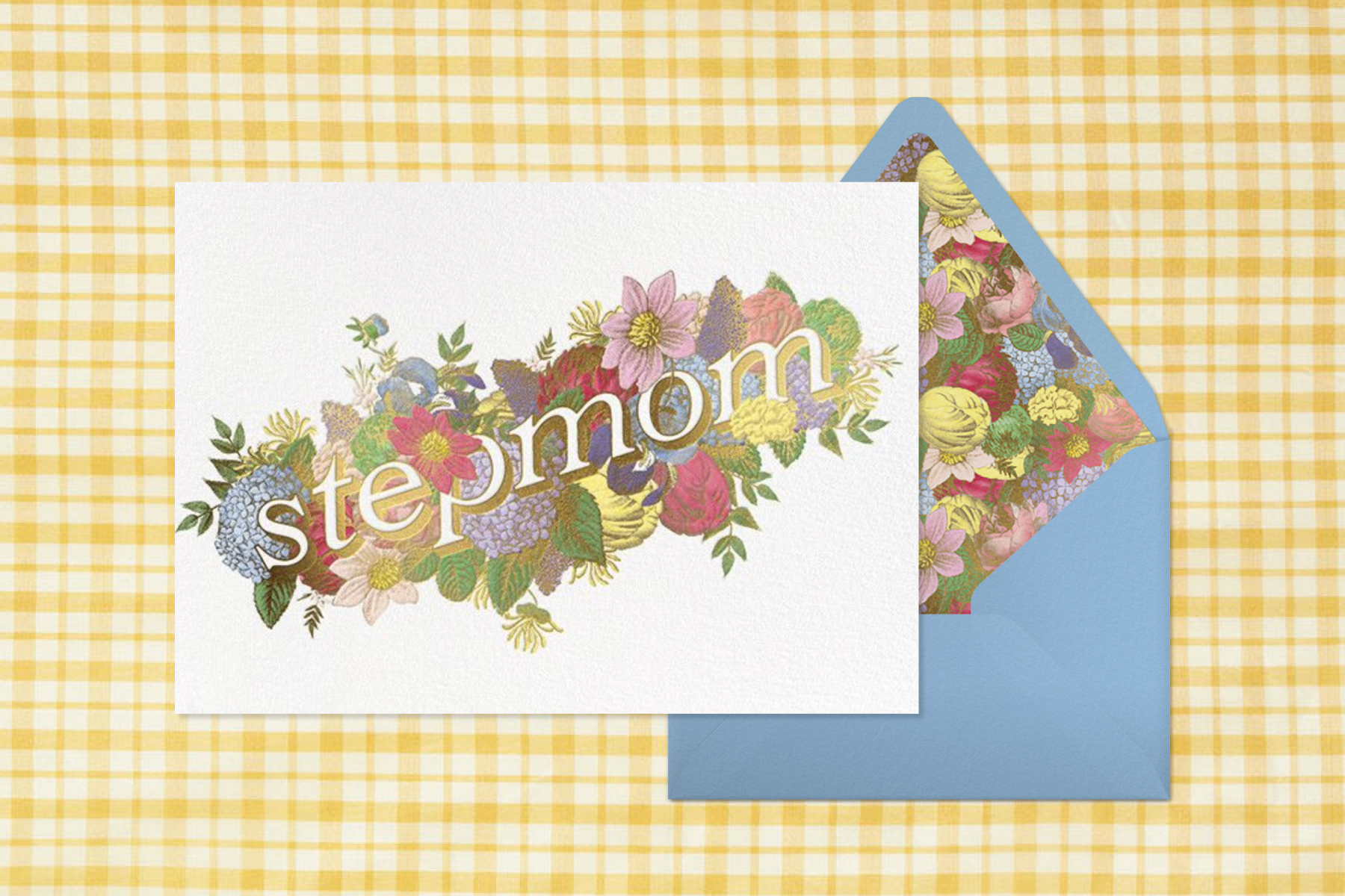 A white card with colorful flowers around the word ‘Stepmom’ on a yellow plaid background next to a blue envelope with similar floral illustrations.