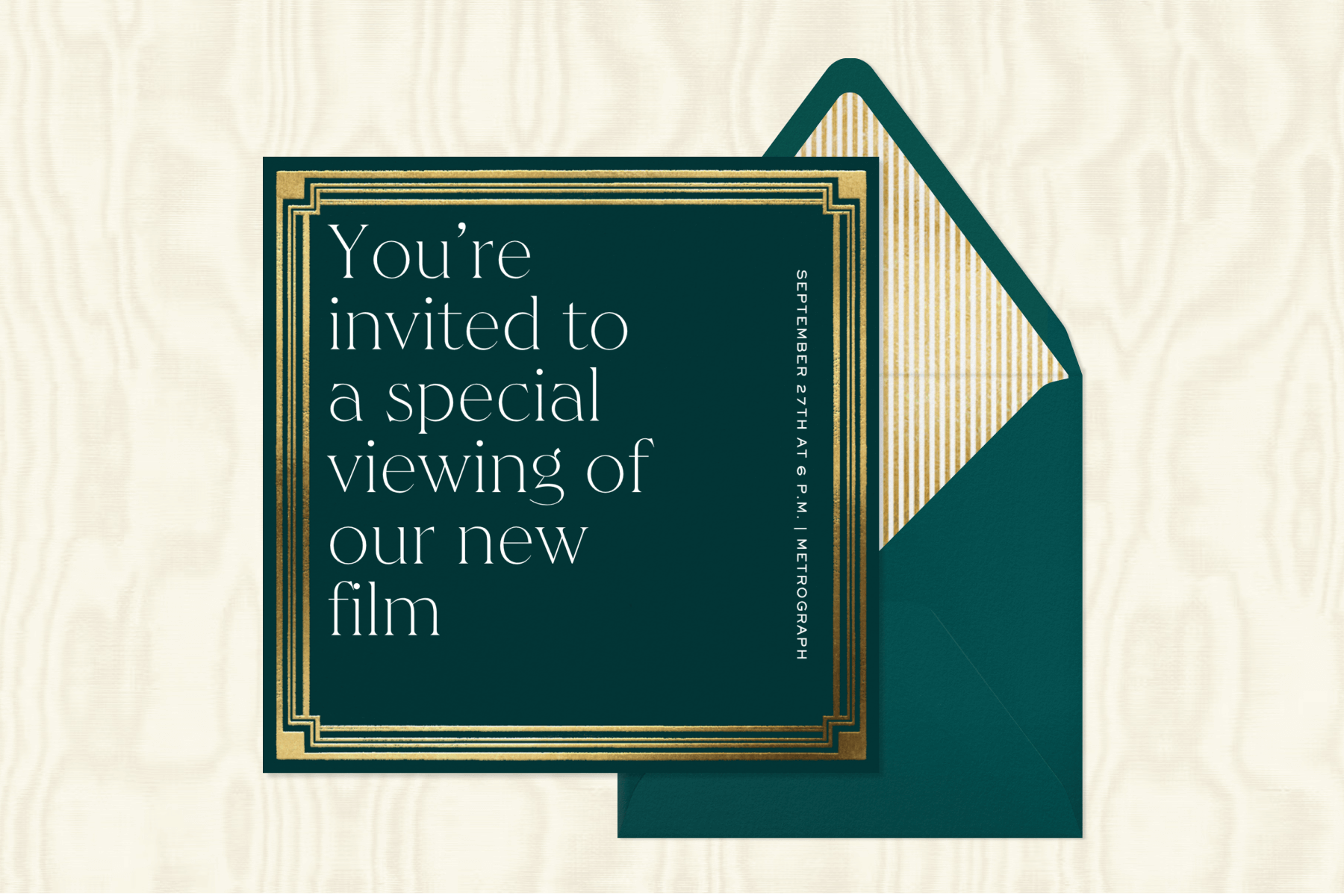 A dark green invitation sits on a cream fabric background, featuring text that reads “You’re invited to a special viewing of our new film,” a modern gold border, and a dark green envelope with a gold and white striped envelope liner.