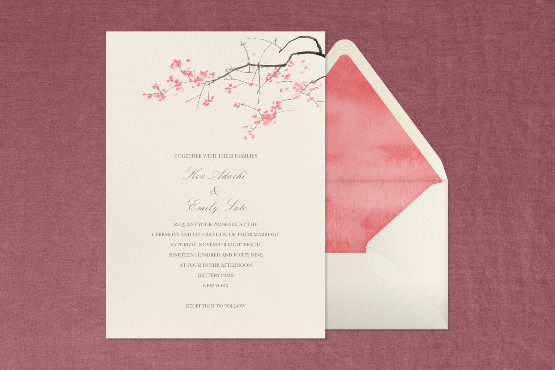A wedding invitation with a cream background and pink and brown cherry blossom illustration at the top paired with a cream envelope, textured pink envelope liner, and textured mauve background.