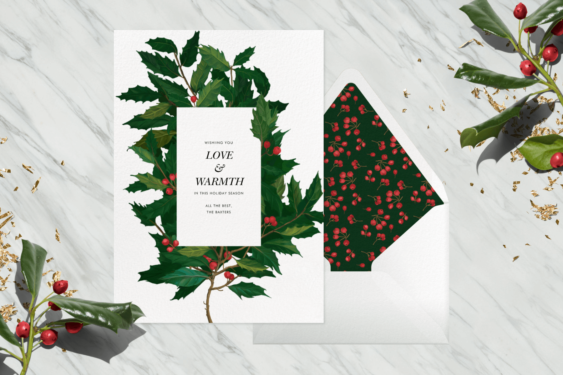 A card with a large branch of holly next to an envelope with a holly berry liner.