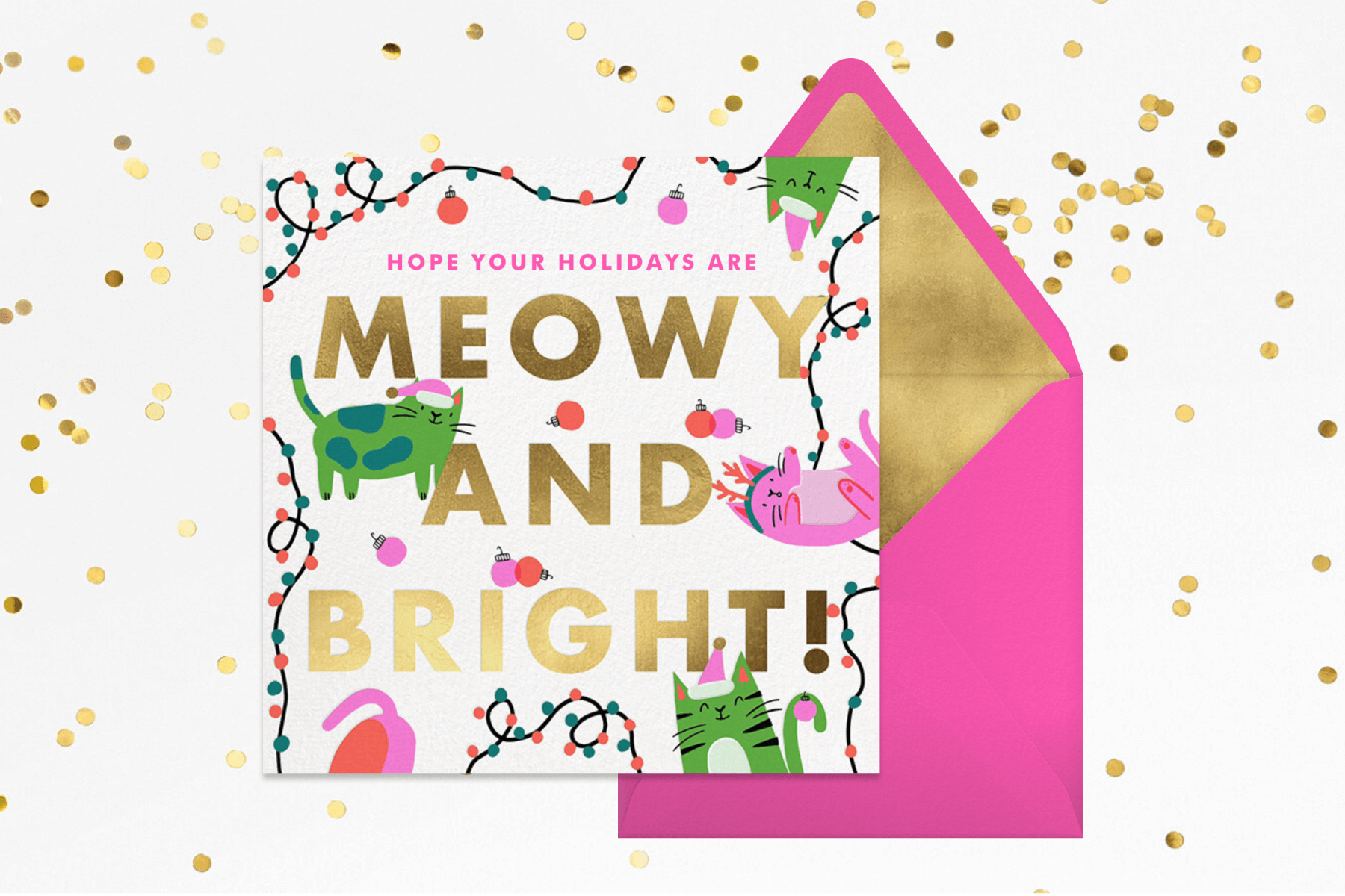 A card with green ans pink cars in Santa hats and antlers playing with ornaments and string lights and the words “Meowy and bright.”