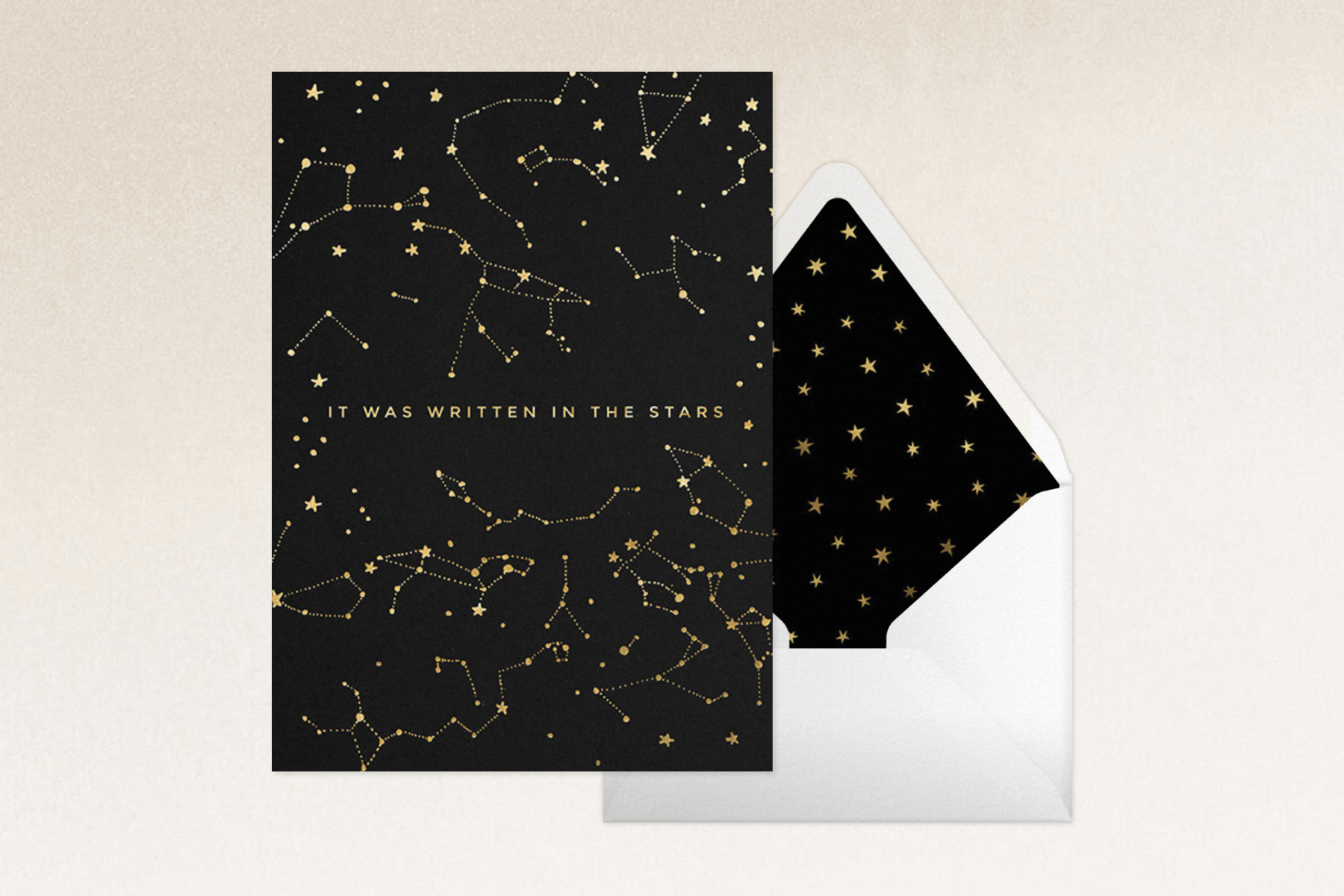 A black card that says ‘it was written in the stars’ with gold constellations.