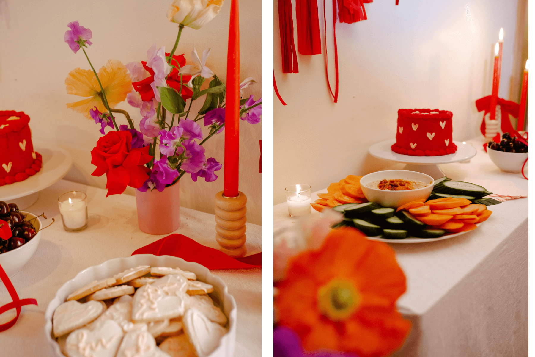 A table with colorful flowers, red candles, a bowl of cherries, and a bowl of heart-shaped cookies; A table with a red cake with white hearts and a tray of vegetables and dip.