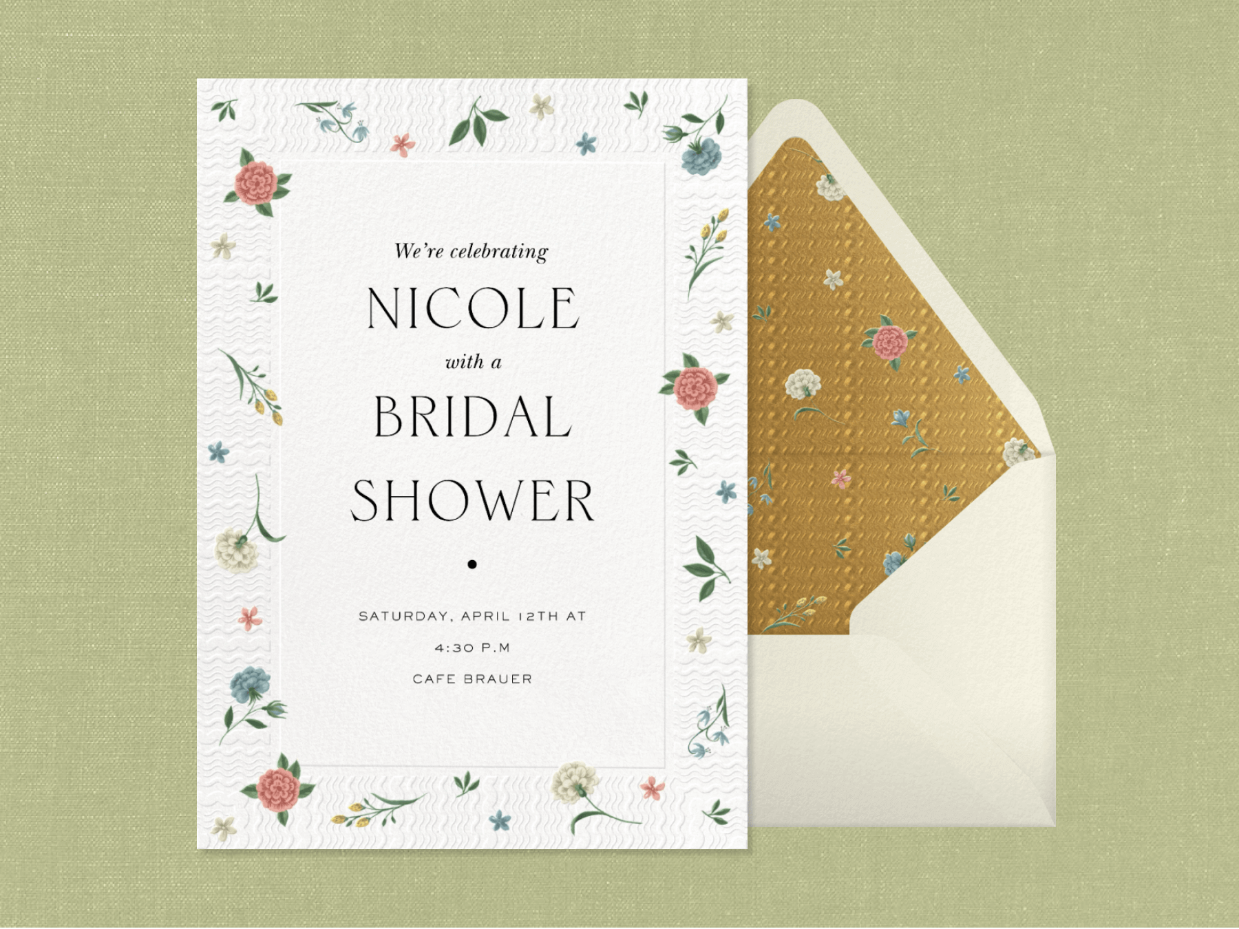 A bridal shower invitation with a textured border and small blue, pink, and white roses sprinkled, beside a white envelope with gold and floral liner.