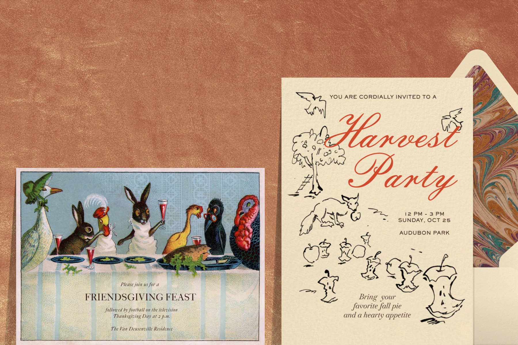 A vintage-style Friendsgiving invitation with illustrations of woodland creatures at a long table sits beside a cream invitation with red script text reading ‘Harvest party’ and black line drawings of a fox, a tree, birds, and apple cores, in front of a cream envelope with a marbled liner, all against a textured terracotta backdrop.