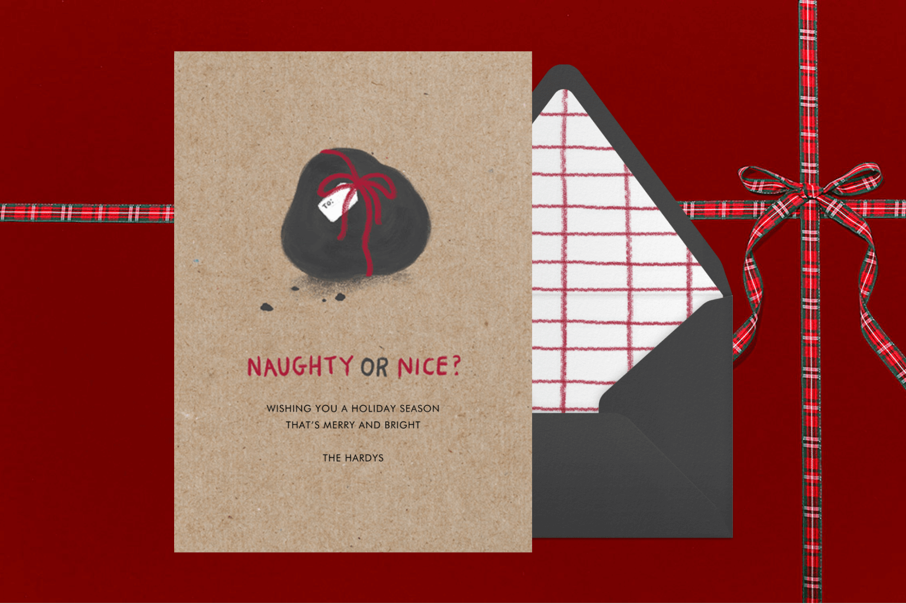 A card with a lump of coal tied in a red ribbon and the words “naughty or nice?”
