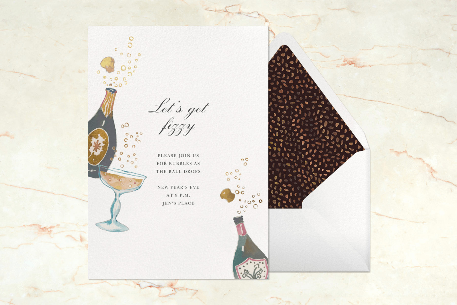 A card with watercolor illustrations of Champagne bottles and coupe glasses reads “Let’s get fizzy” on a marble background.
