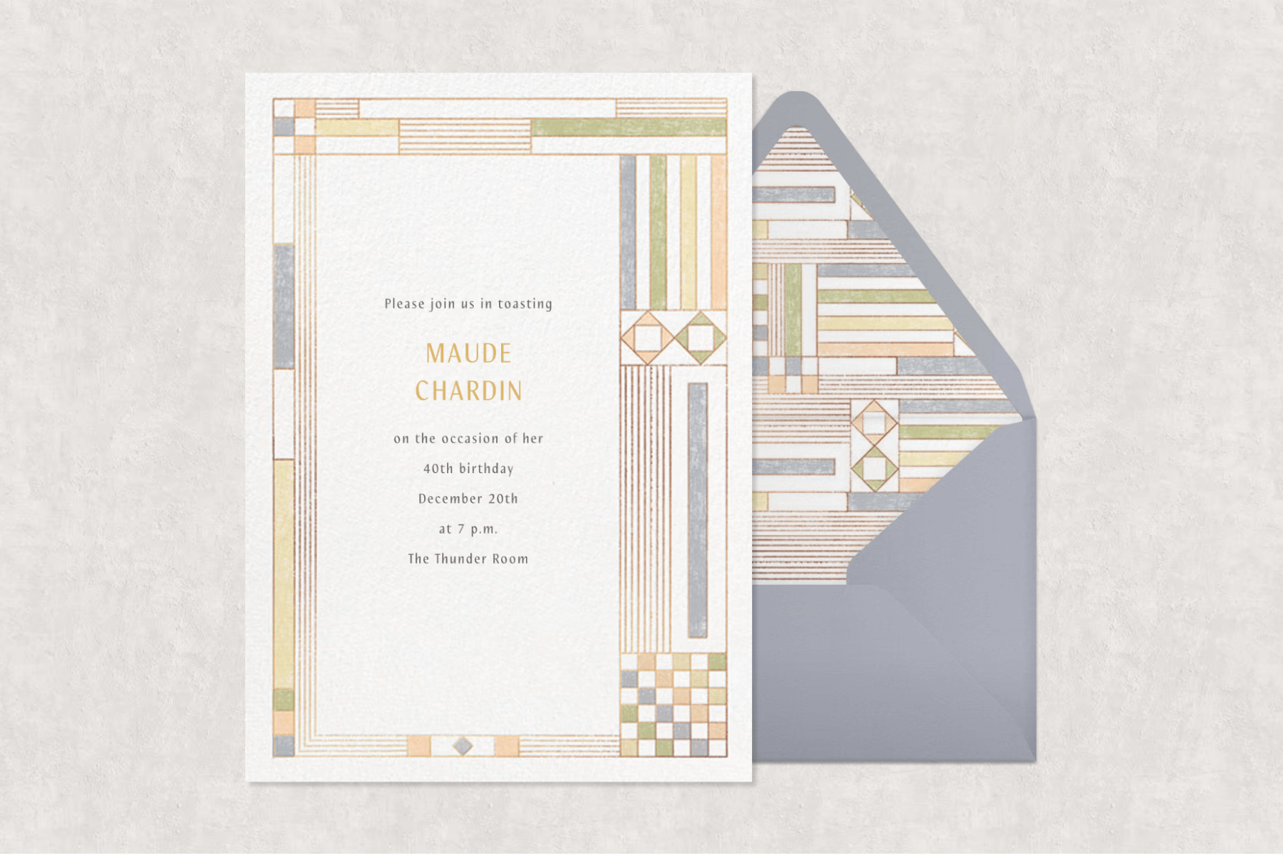 An Art Deco birthday party invitation with a geometric green, yellow, peach, and gray border paired with a matching envelope liner and gray envelope on a gray background.