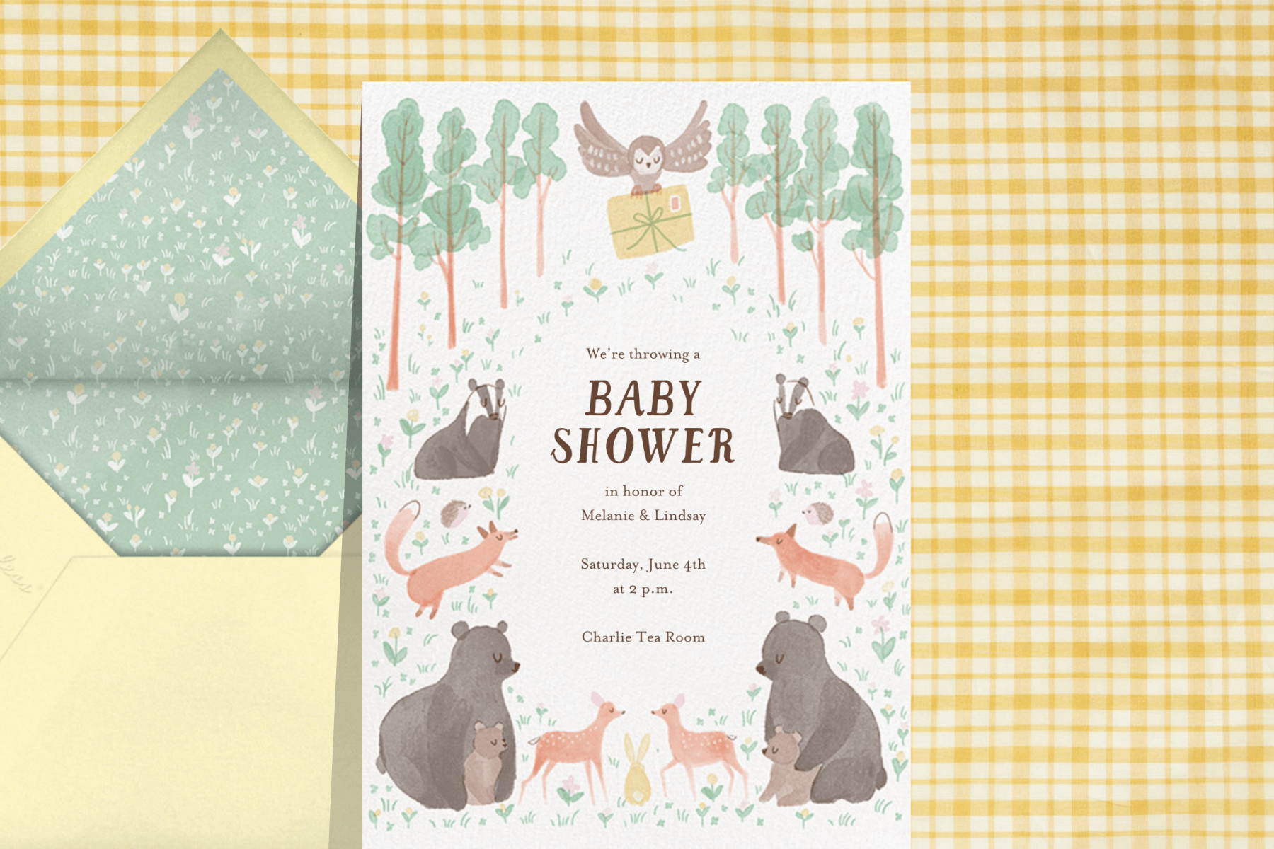 A baby shower card featuring woodland creatures like foxes, badgers and bears. An owl carries an invitation.