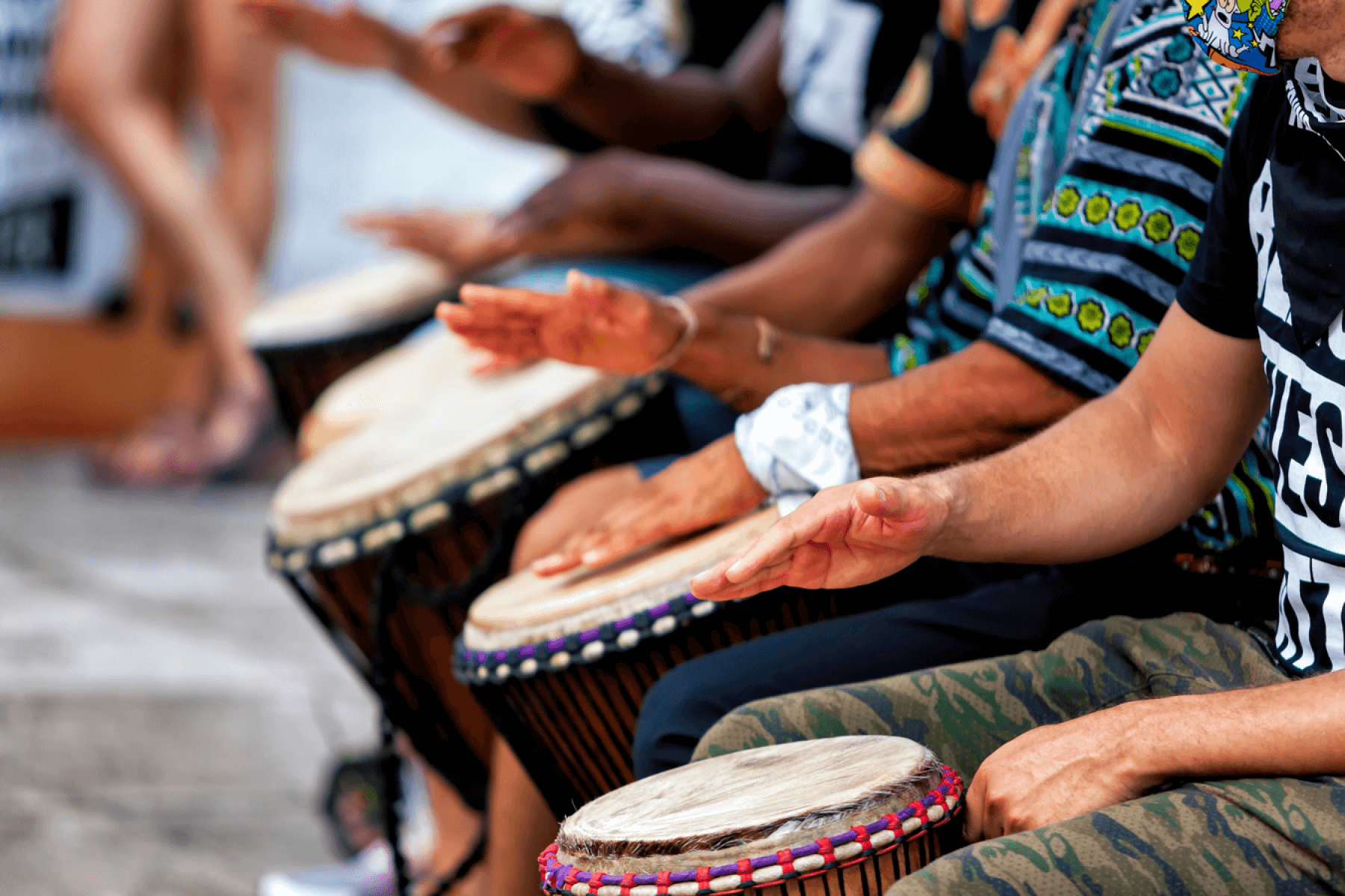 Close up photo of hands drumming on African-style drums.