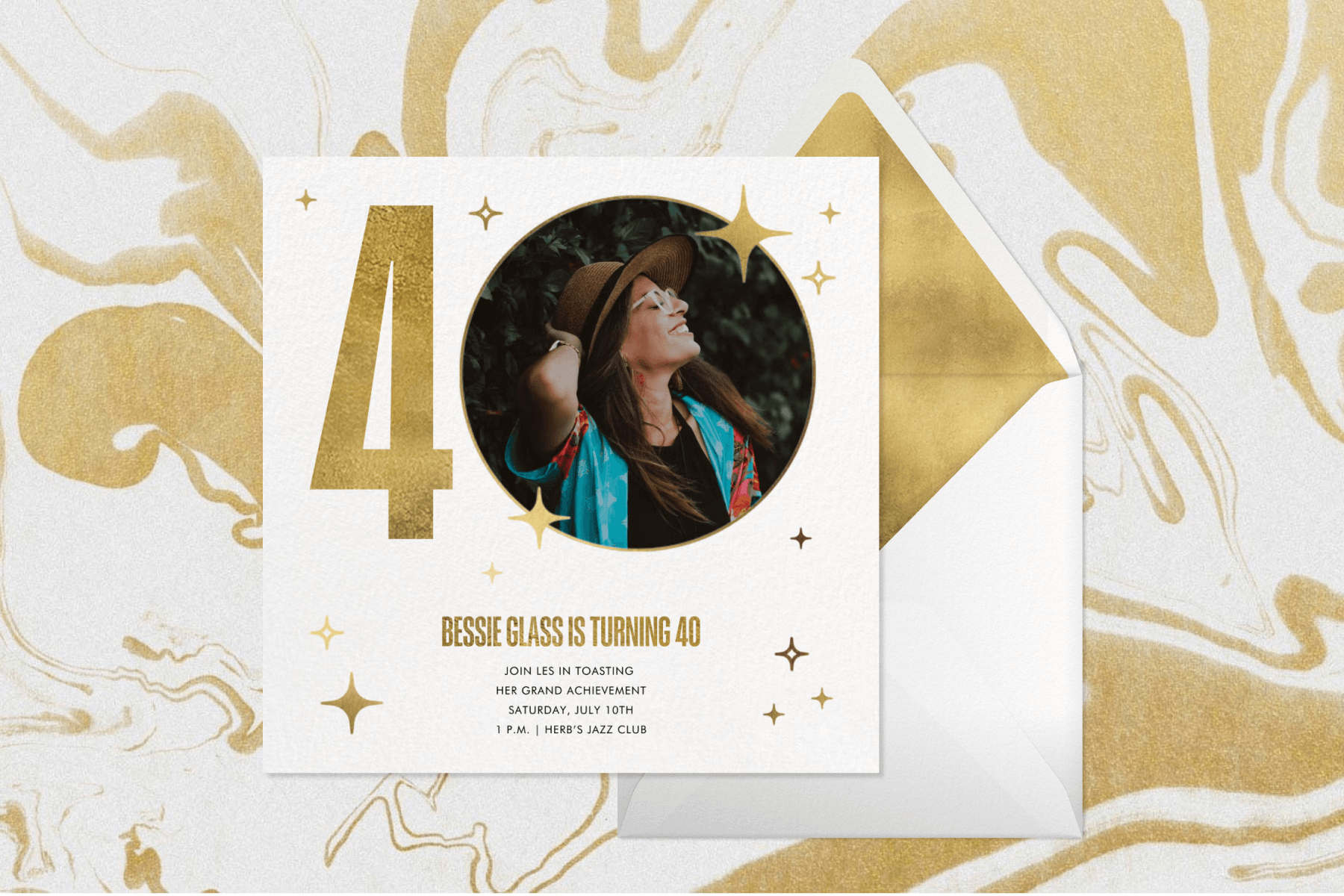 A 40th birthday party invitation with a cream background, gold text and star graphics, and gold ‘40’ text that features a photo of the birthday girl in the center of the zero, paired with a cream envelope and gold envelope liner all on a gold and cream swirled paint background.