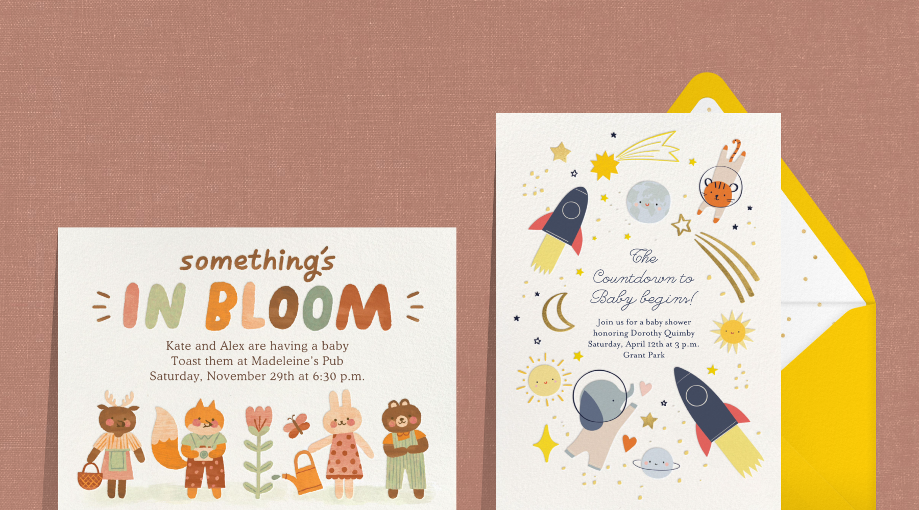 An invitation with forest animals watering a flower reads ‘something’s in bloom;’ an invitation with rocketships and animal astronauts next to a yellow envelope.