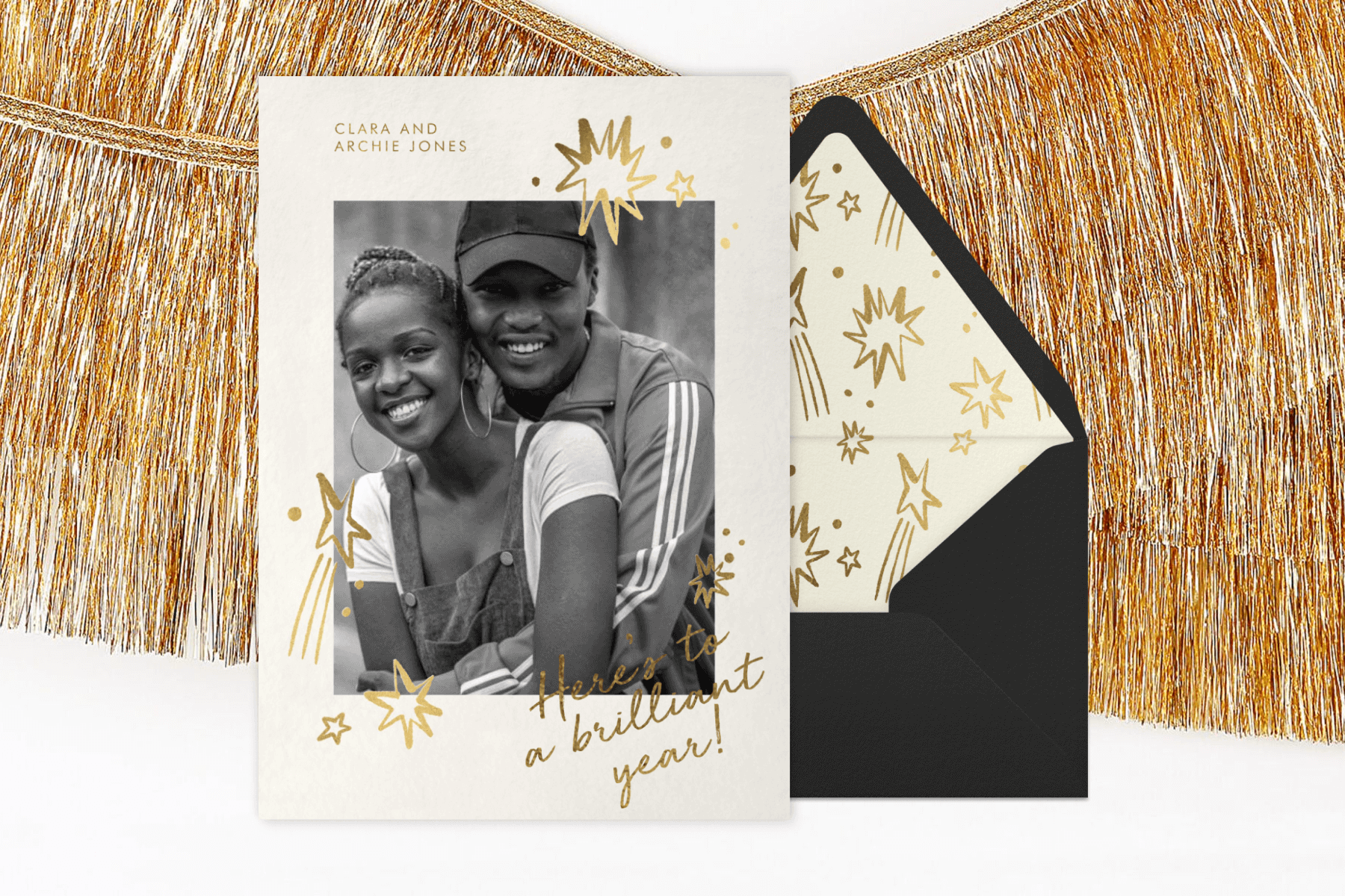 A photo card with gold star details and the script "Here's to a brilliant year!"