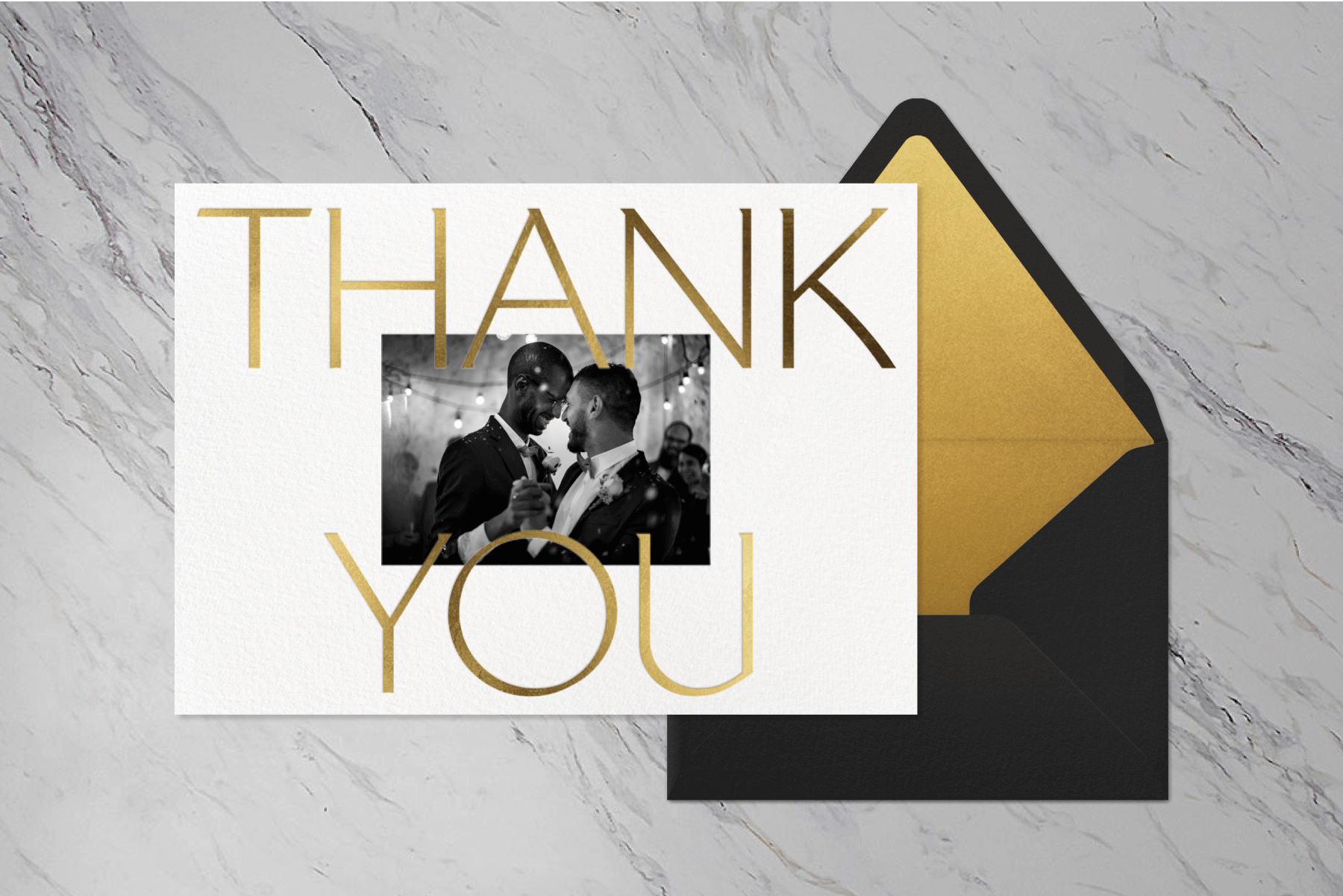 A thank you card with a black and white photo of two men in tuxes dancing and large gold lettering.