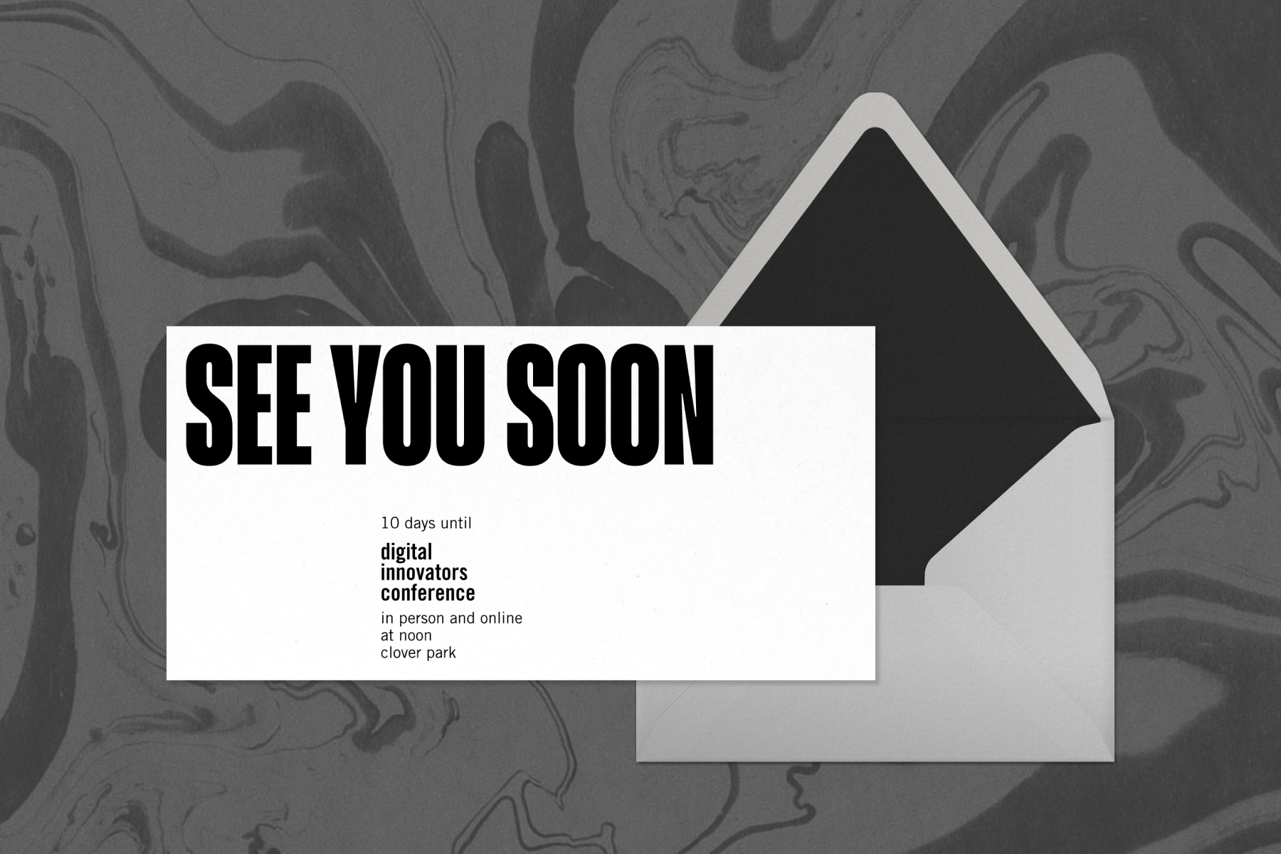 A long horizontal white invitation with large black text reading ‘SEE YOU SOON’ with a white envelope with a black liner over a black and grey marbled background.