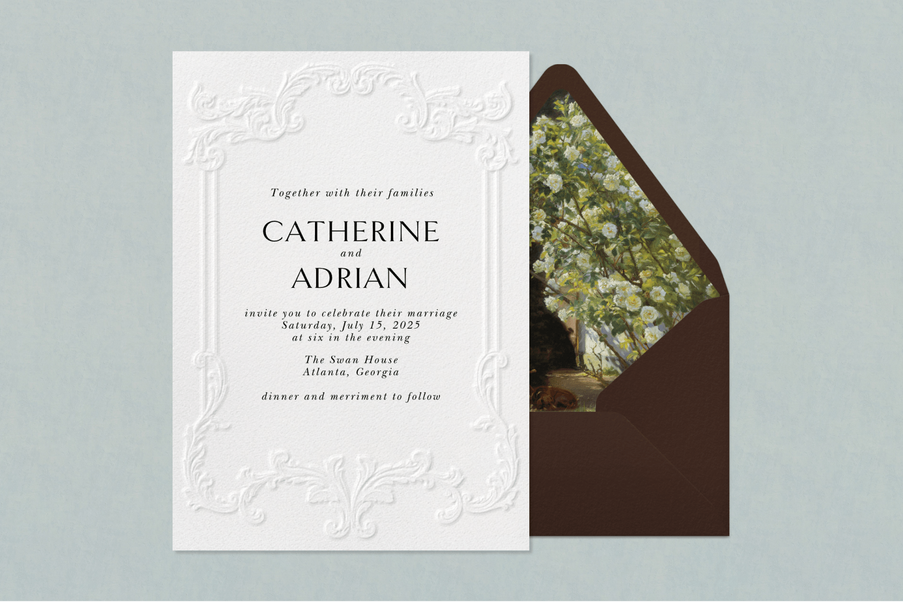 An ornately embossed ivory wedding invitation sits to the left of a brown envelope with a floral interior against a textured powder-blue backdrop.