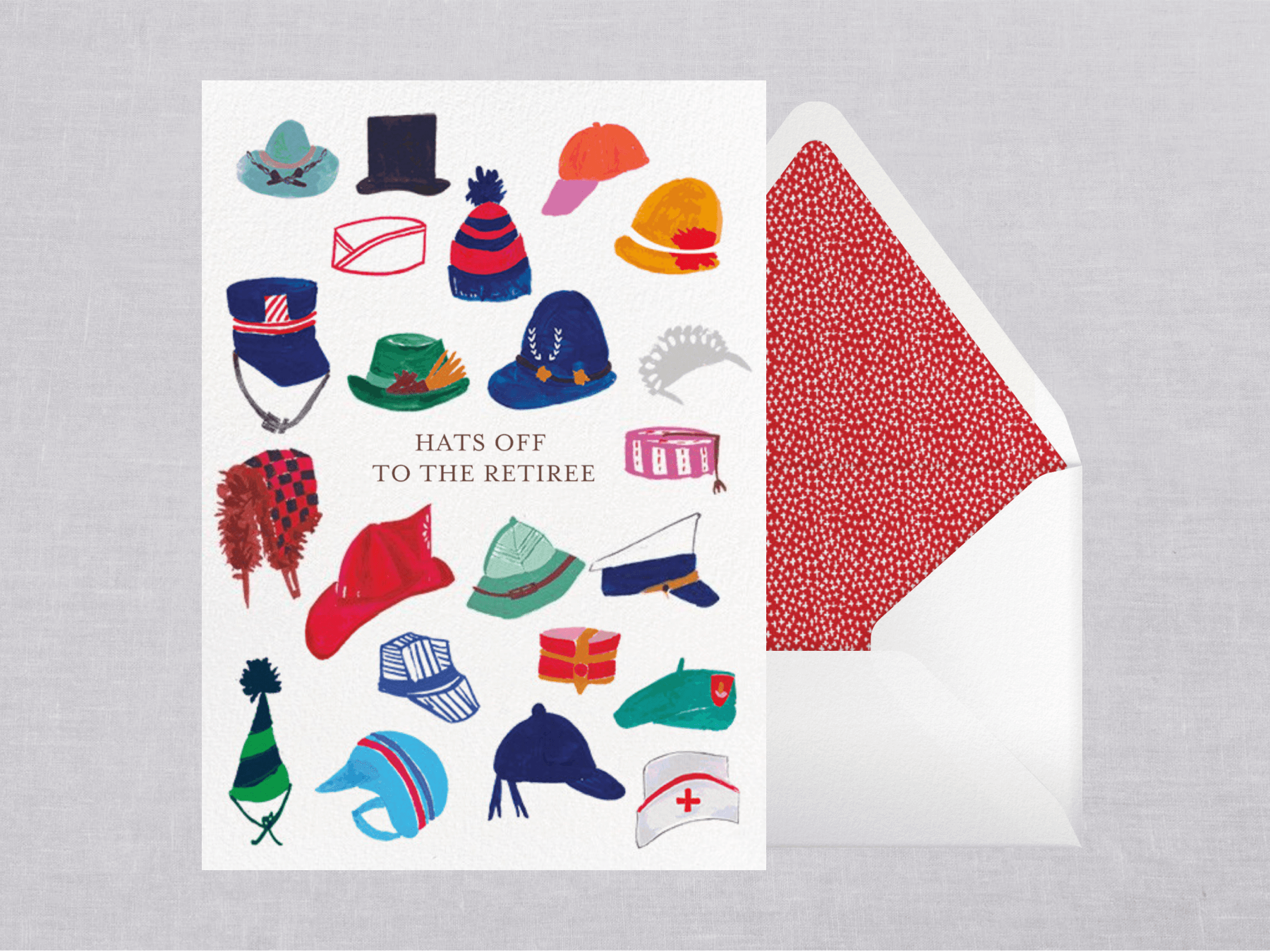 A greeting card with small paintings of assorted colorful hats reads “Hats off to the retiree” beside a white envelope with red polka dot liner.