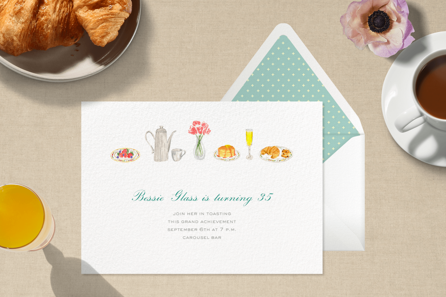 An invitation for a 35th birthday has small watercolors of brunch items at the top such as pancakes, strawberries, flowers, and croissants. In the background is orange juice, croissants, and a cup of coffee.