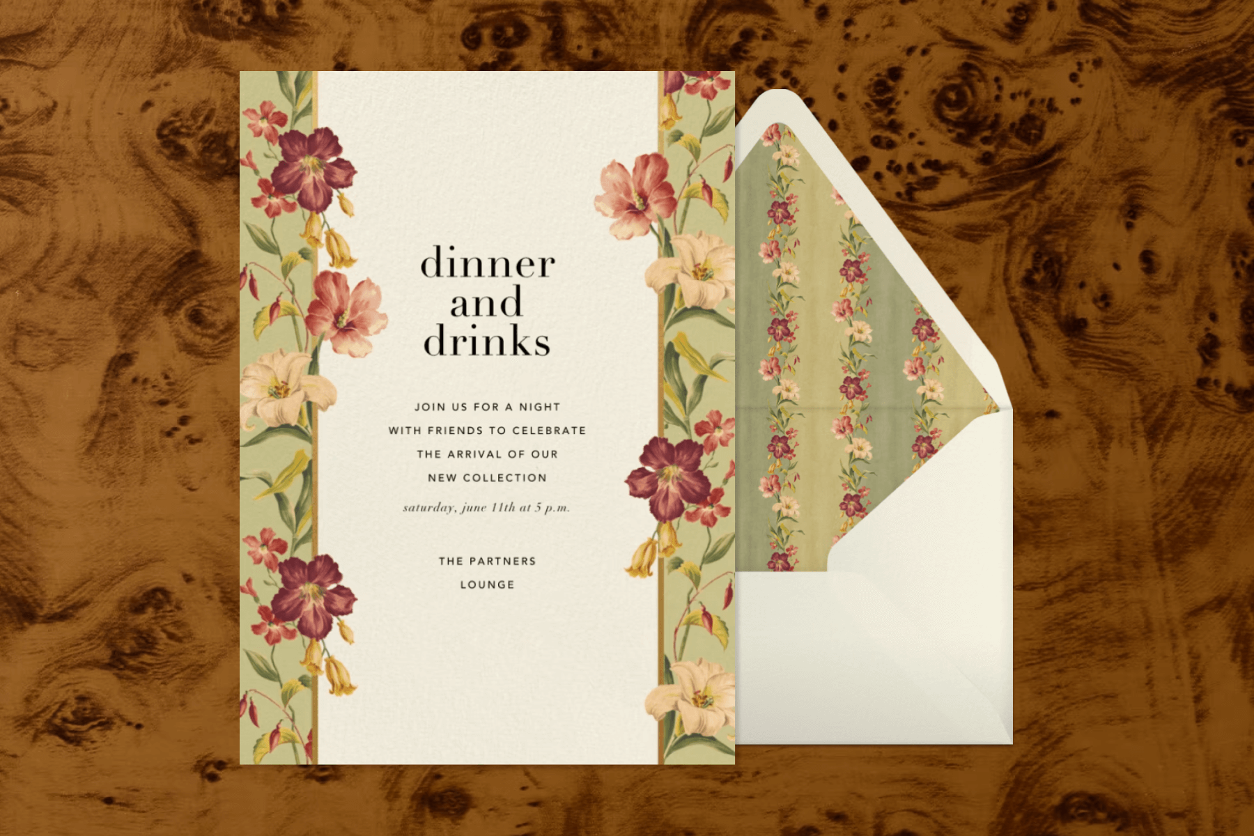 An invitation with black text reading ‘DINNER AND DRINKS’ and a pale green border with white and red florals, next to a white envelope with a matching floral liner. \