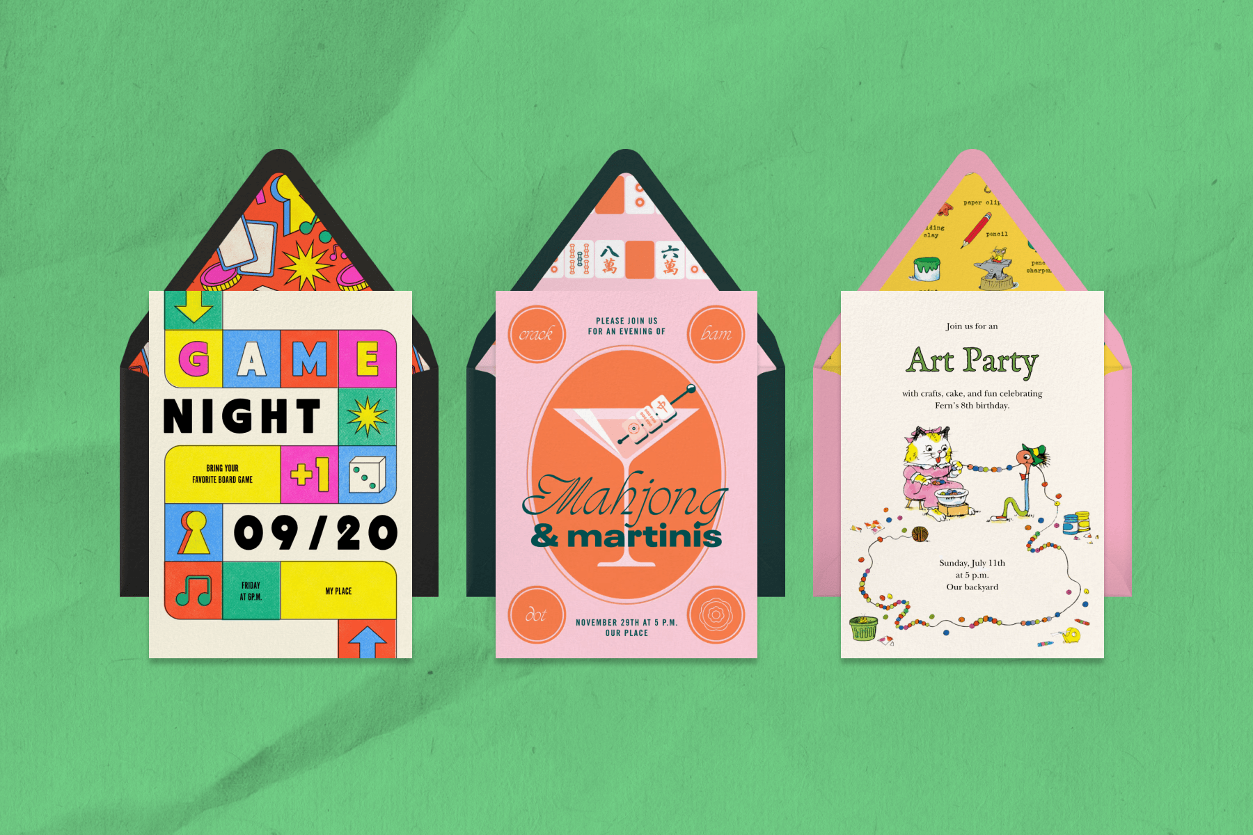 Three invitations side by side on a green paper background: left, an invitation to a game night with a colorful board game design sits on a black envelope; center, a pink invitation on top of a black envelope reading ‘Mahjong & martinis’; right, an invitation to an art party featuring the Richard Scarry cat and worm beading a ball of yarn, set on a pink envelope. 