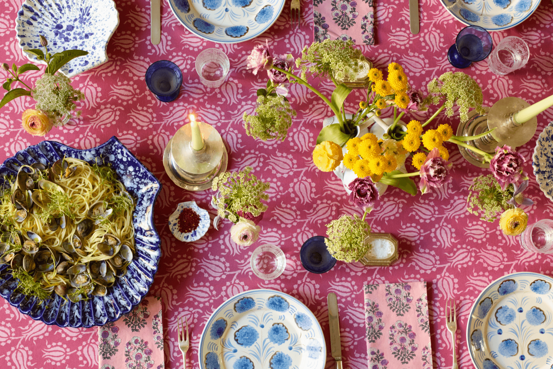 overhead shot of a blue and pink tablescape with clam pasta