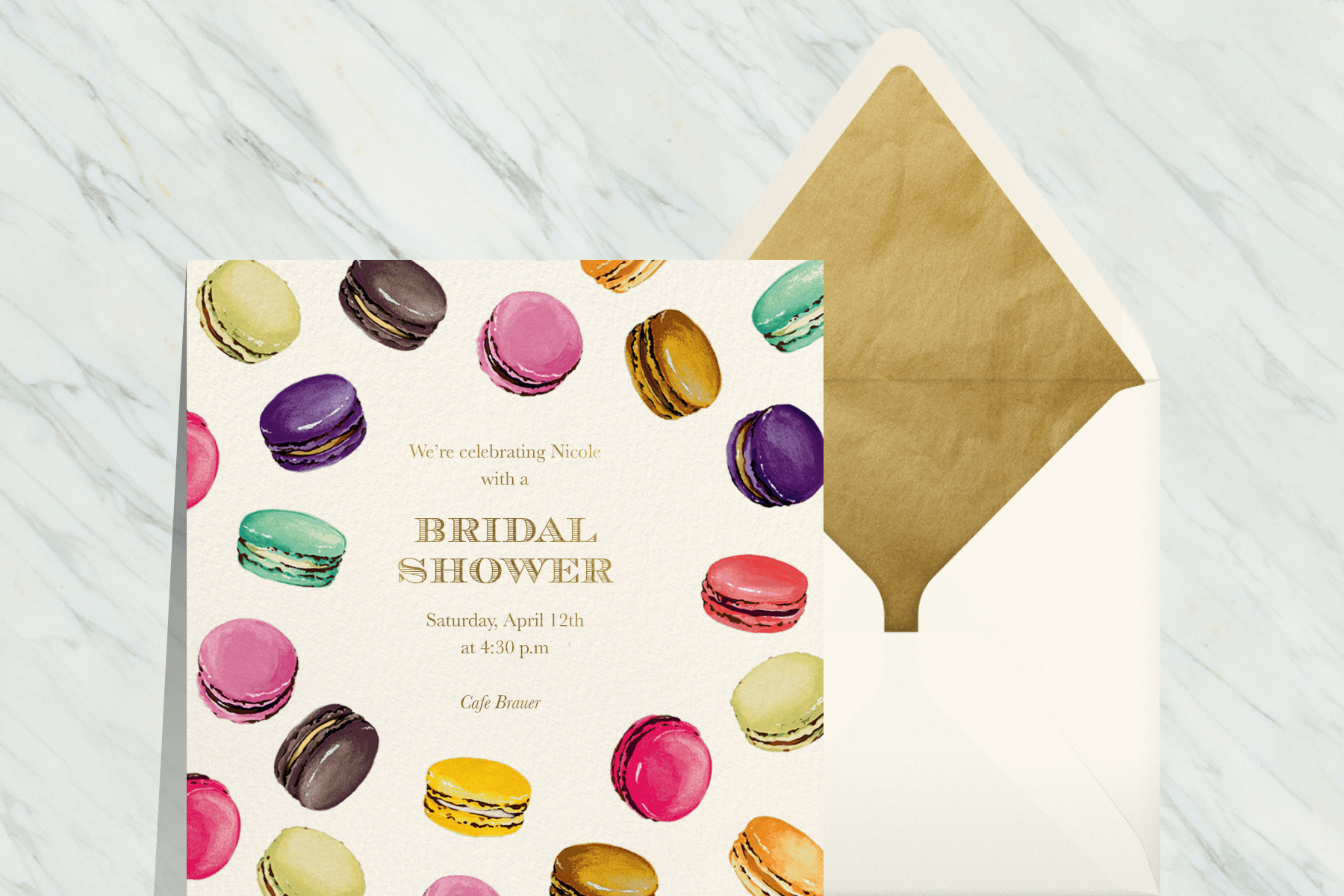 A bridal shower invitation with various collors of illustrated macarons surrounding the text.