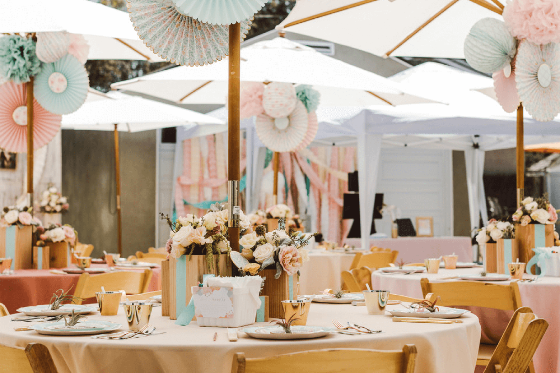 outdoor tables and umbrellas with pastel party decorations