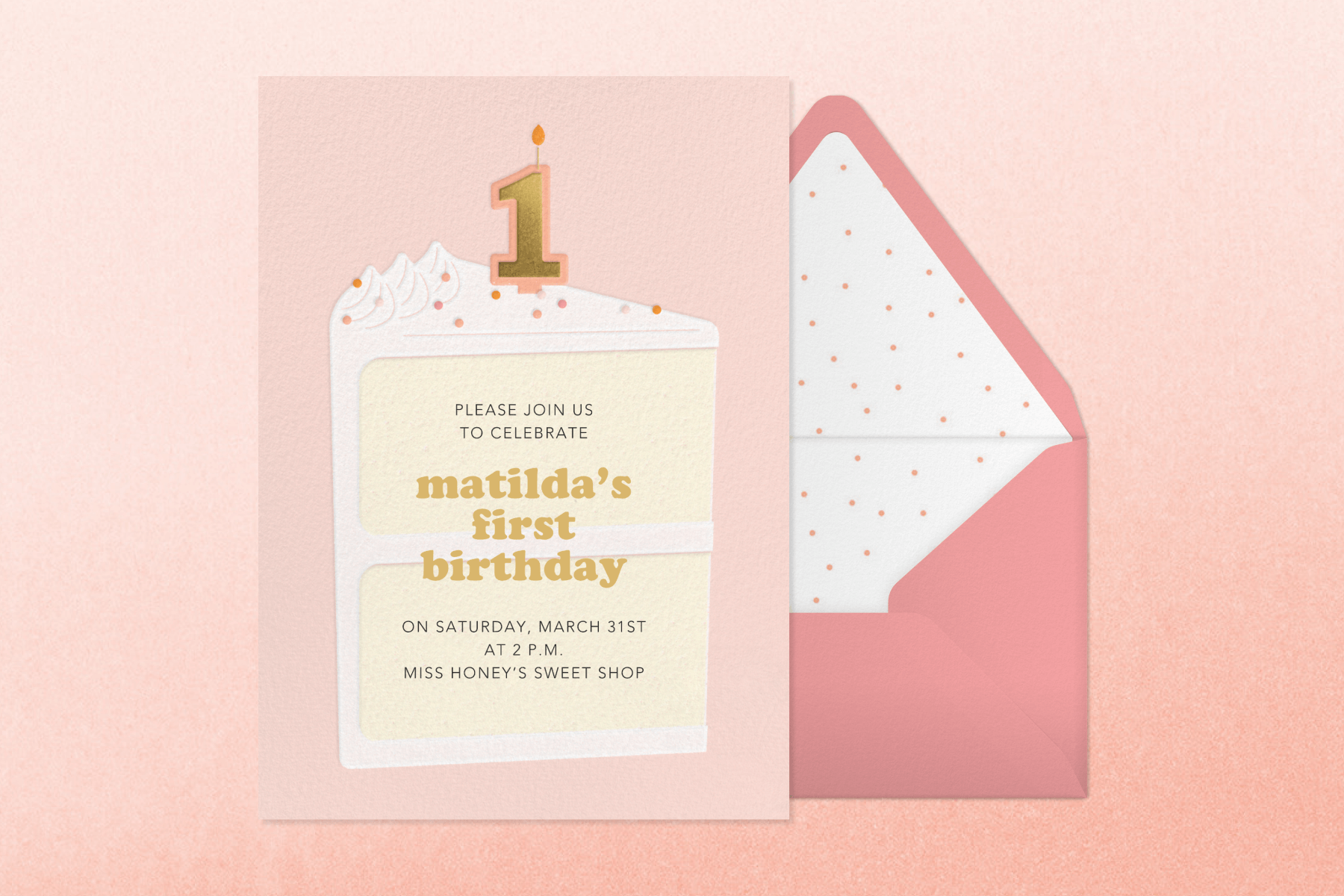 A pink birthday invitation reads “Matilda’s first birthday” with a large slice of vanilla cake and a “1” candle on top beside a pink envelope.
