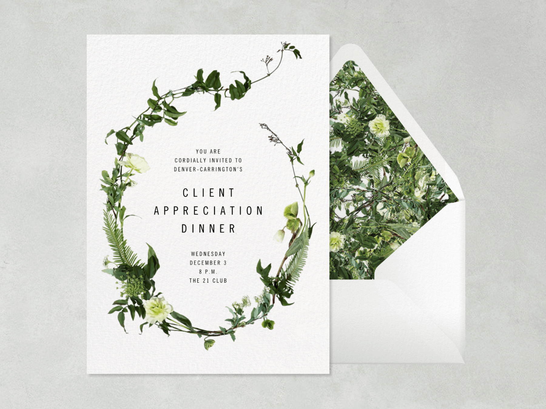 A Client Appreciation Dinner invitation with a green vine and leaves in a wild oval shape, beside a white envelope with matching greenery liner.
