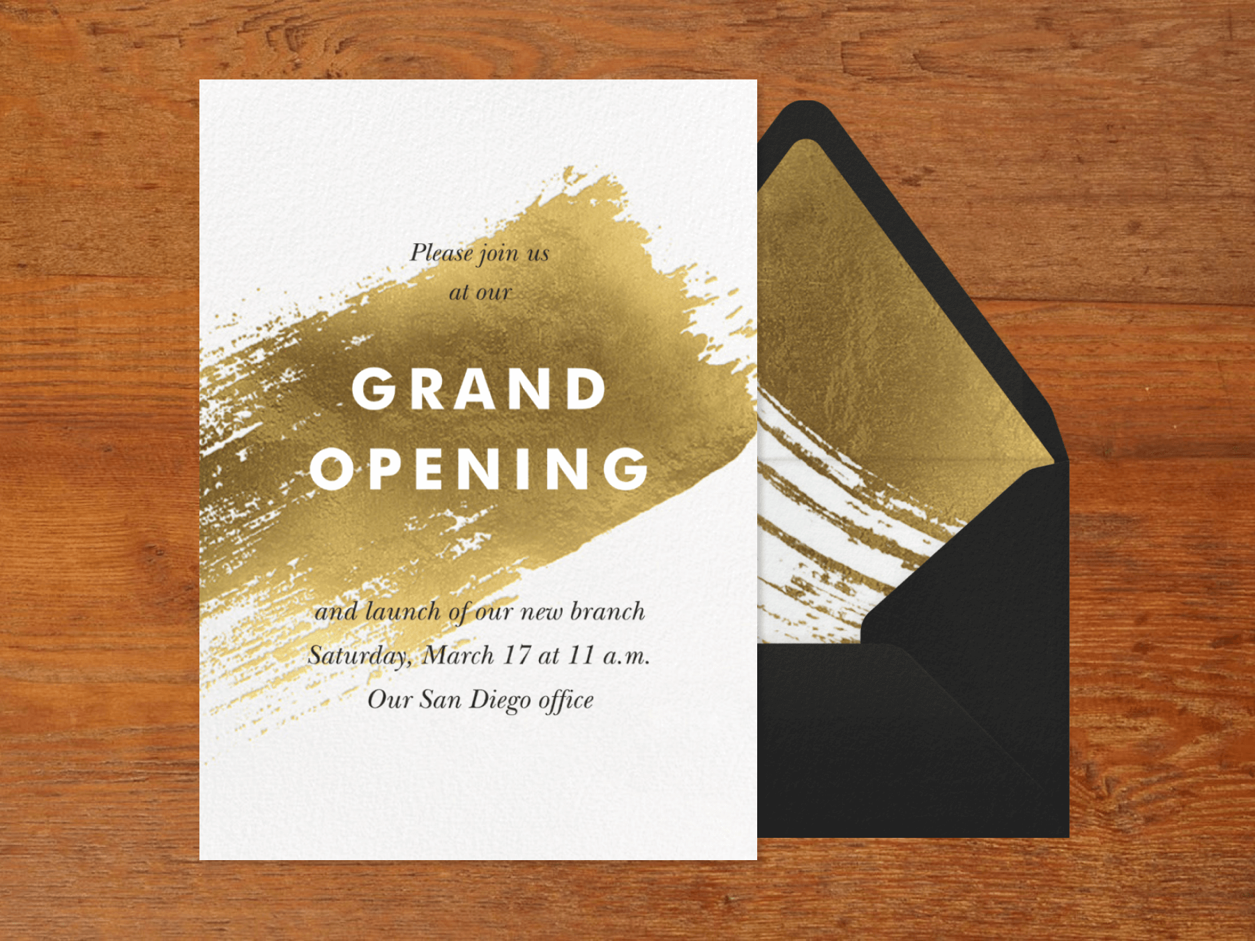 An invitation for a grand opening with a large gold brush stroke across the center.