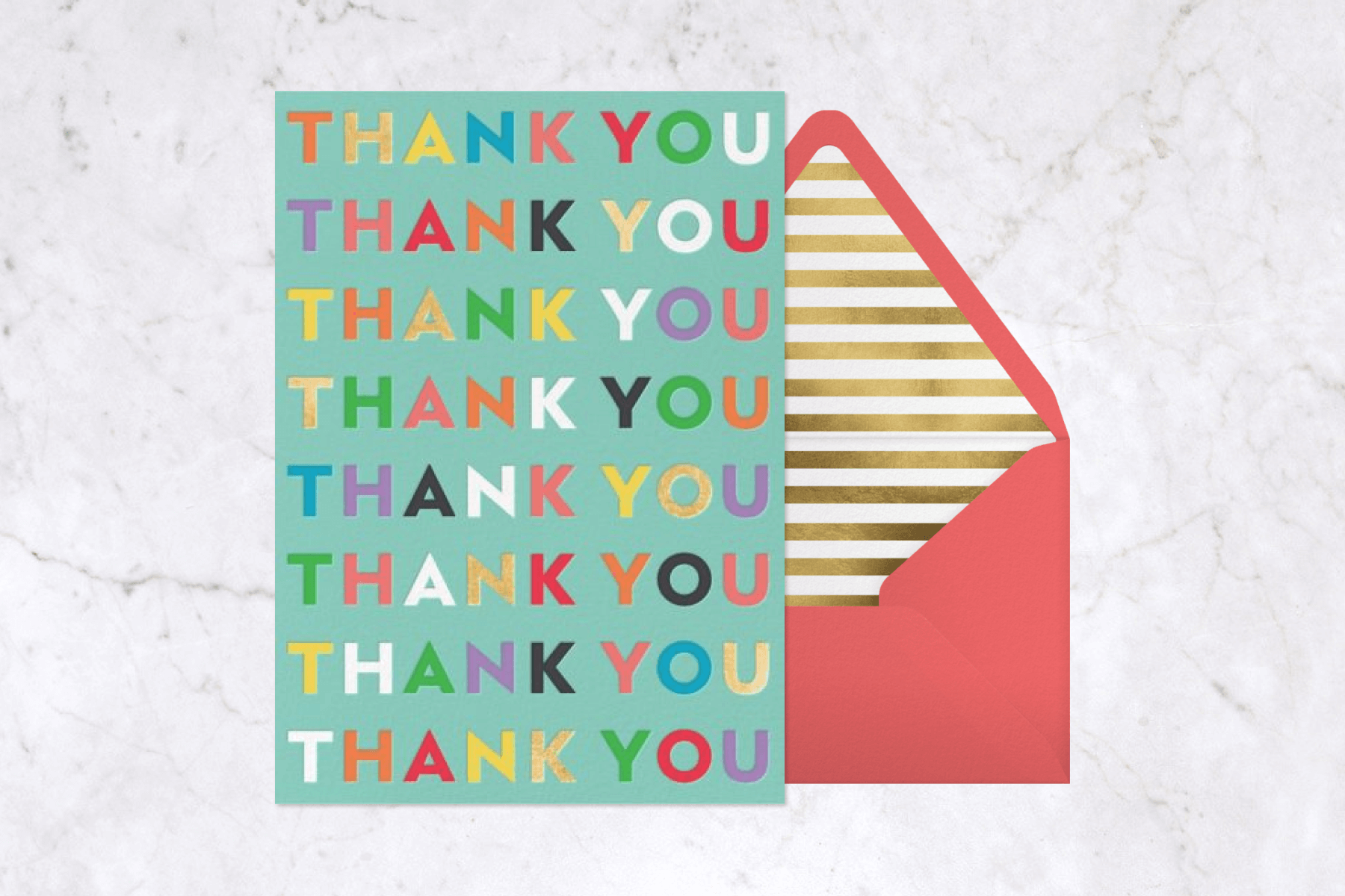 An aqua colored invitation has the words “Thank you” repeated many times in rainbow letters, beside a salmon colored envelope with gold striped liner.